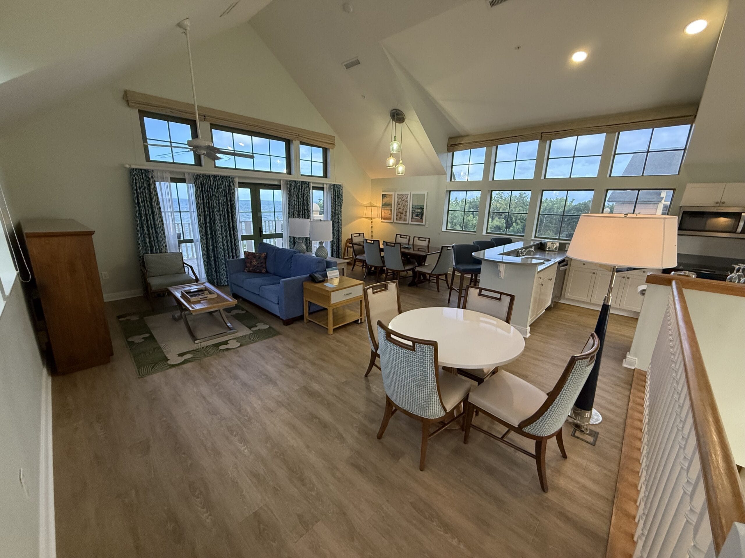 Cozy living and dining space in a 3-bedroom cottage, featuring large windows, wood floors, and an open kitchen—no Disney castle seen.