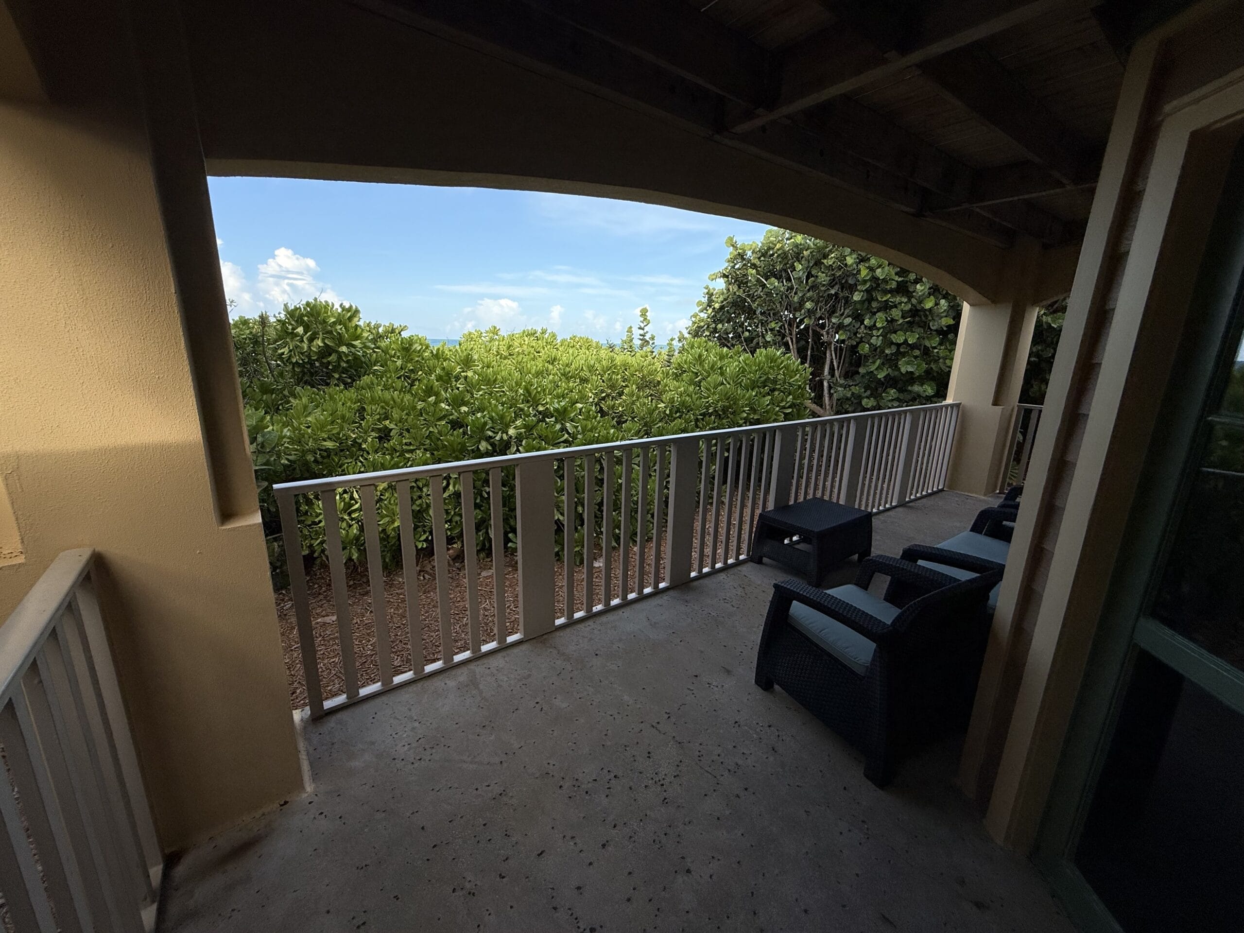A shaded patio with chairs overlooks lush greenery at Disney’s Vero Beach Resort 3 Bedroom Cottage, a relaxing retreat beyond the parks.