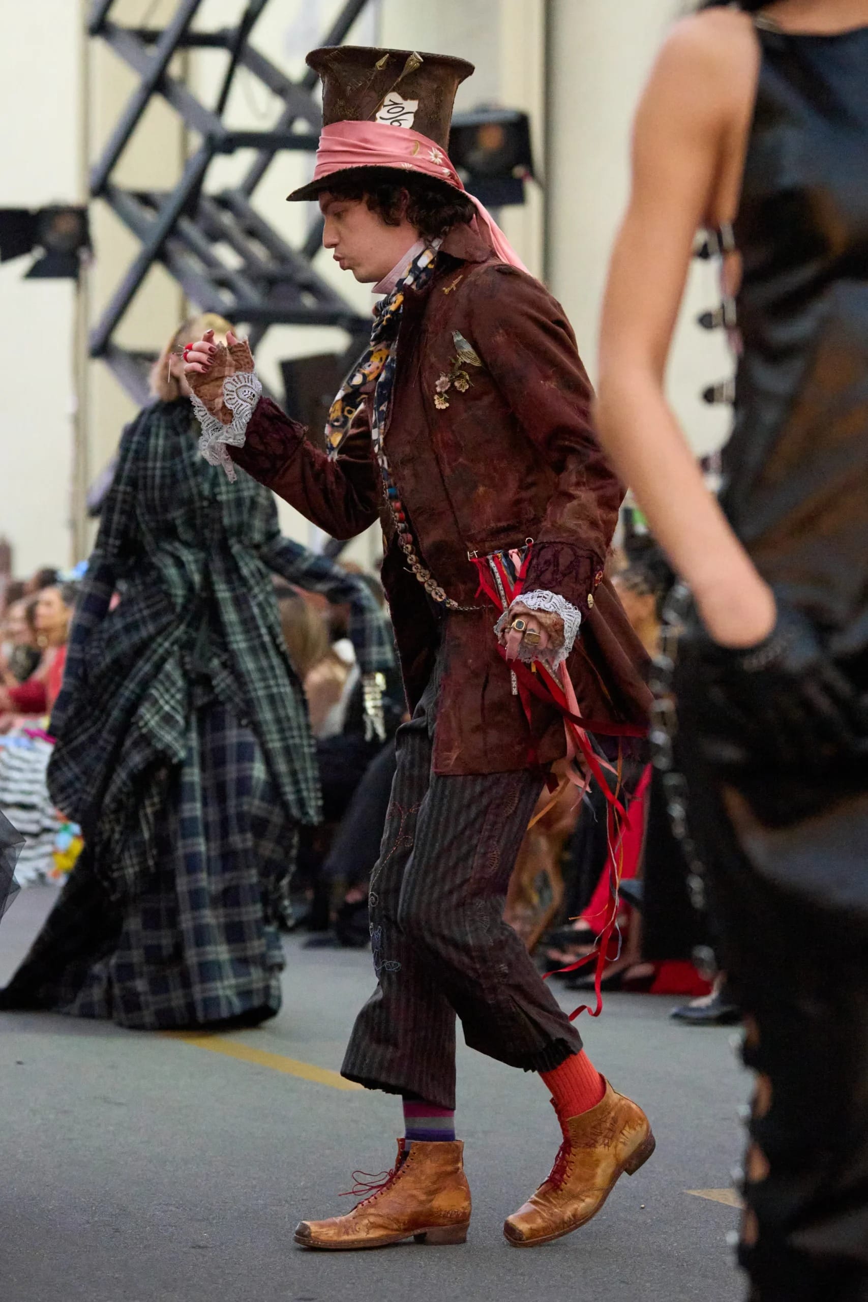 A model channels Mad Hatter flair on the runway, evoking Disney Park whimsy but without any castle like those in Disneyland or Magic Kingdom.