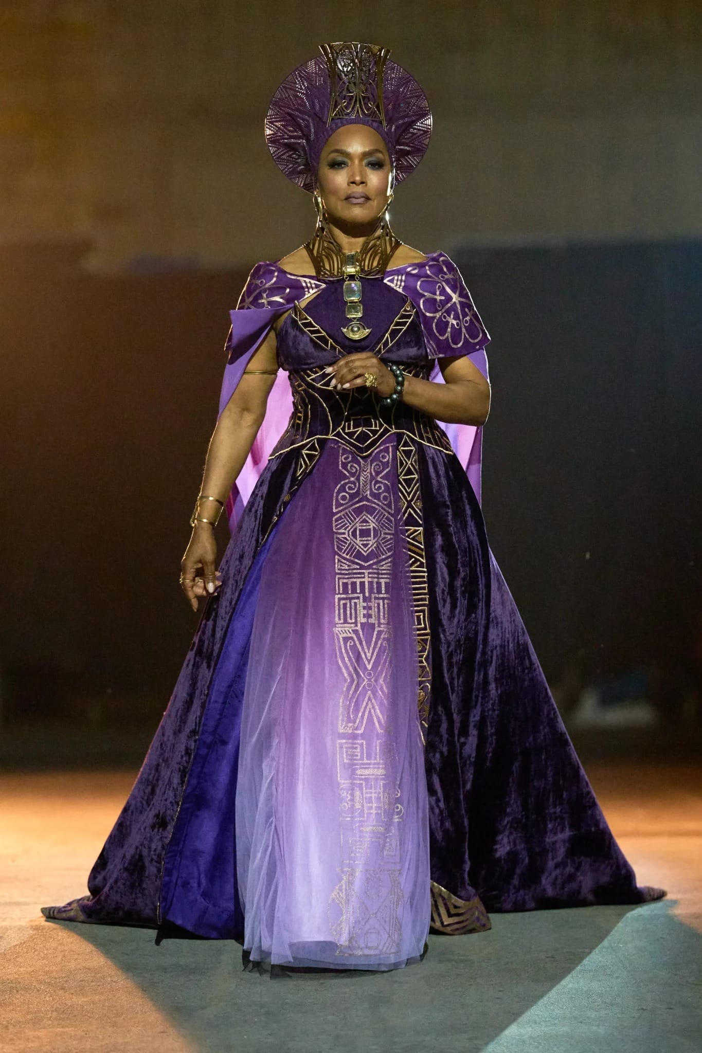 Woman in a regal purple and gold gown, Disney Parks style, poses confidently under dramatic lighting like a princess at Cinderella Castle.