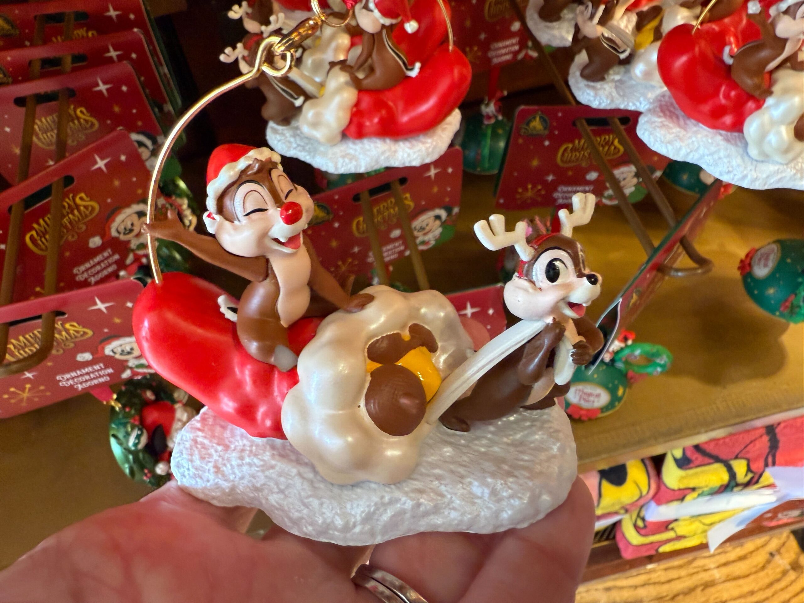 Walt Disney World Christmas merchandise: 2025 Chip and Dale ornament with festive hats, holding an acorn.