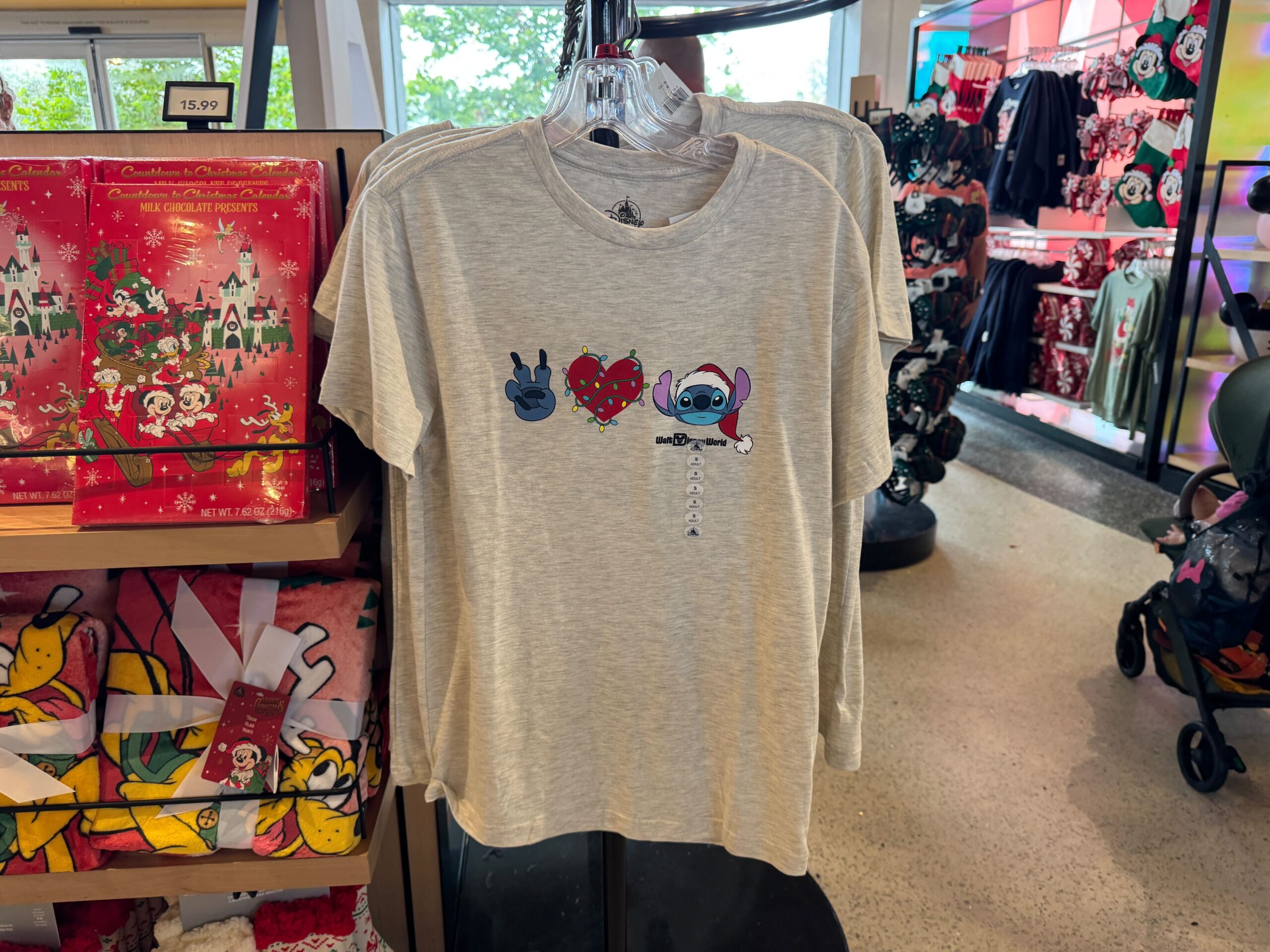 Gray t-shirt featuring Walt Disney World’s Stitch with a blaster, black hand, and red heart cartoon graphics.