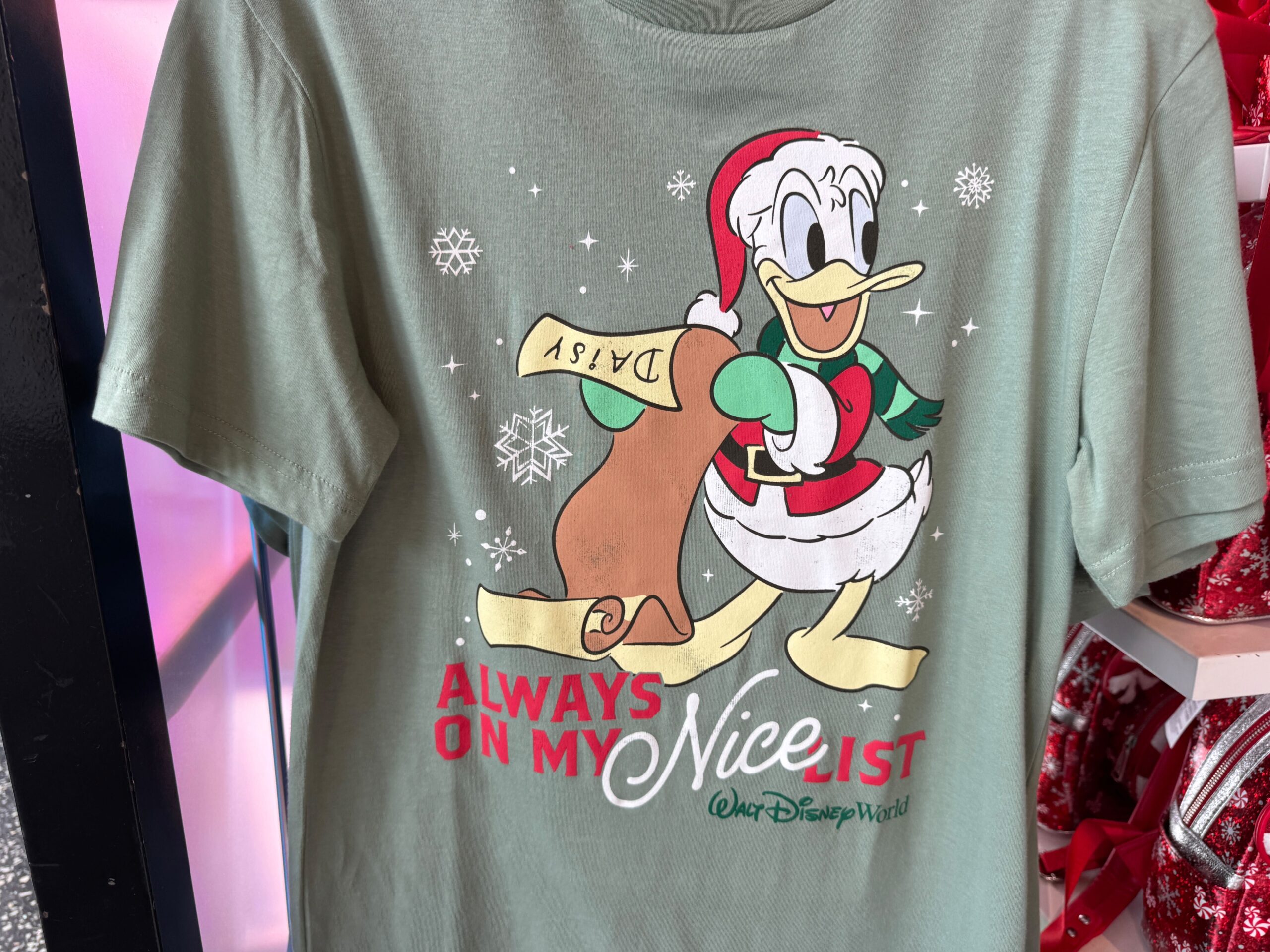 Green T-shirt featuring Donald Duck in a Santa outfit at Walt Disney World, with "Always on my nice list" text.