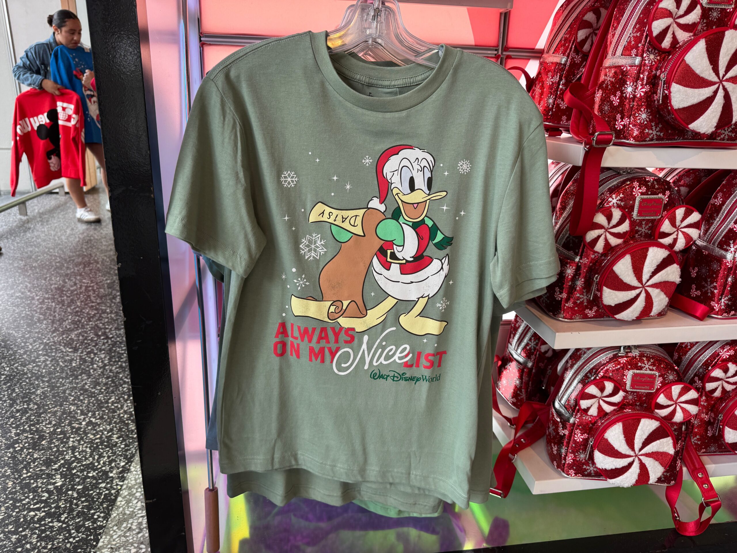 Green t-shirt with Donald Duck holding a list, part of the 2025 Walt Disney World Christmas merchandise collection.