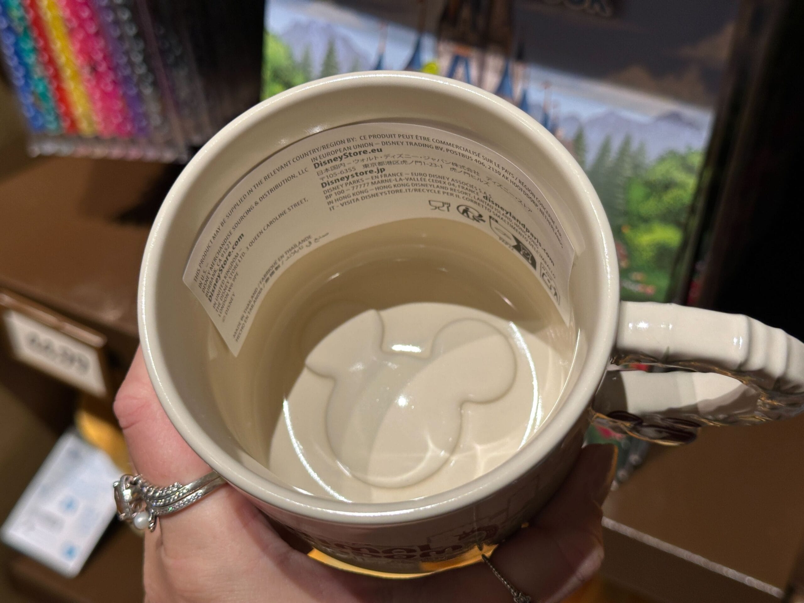 A hand holds a mug featuring a 3D Mickey Mouse head—ideal for Disney’s Animal Kingdom Villas fans, no castle seen.
