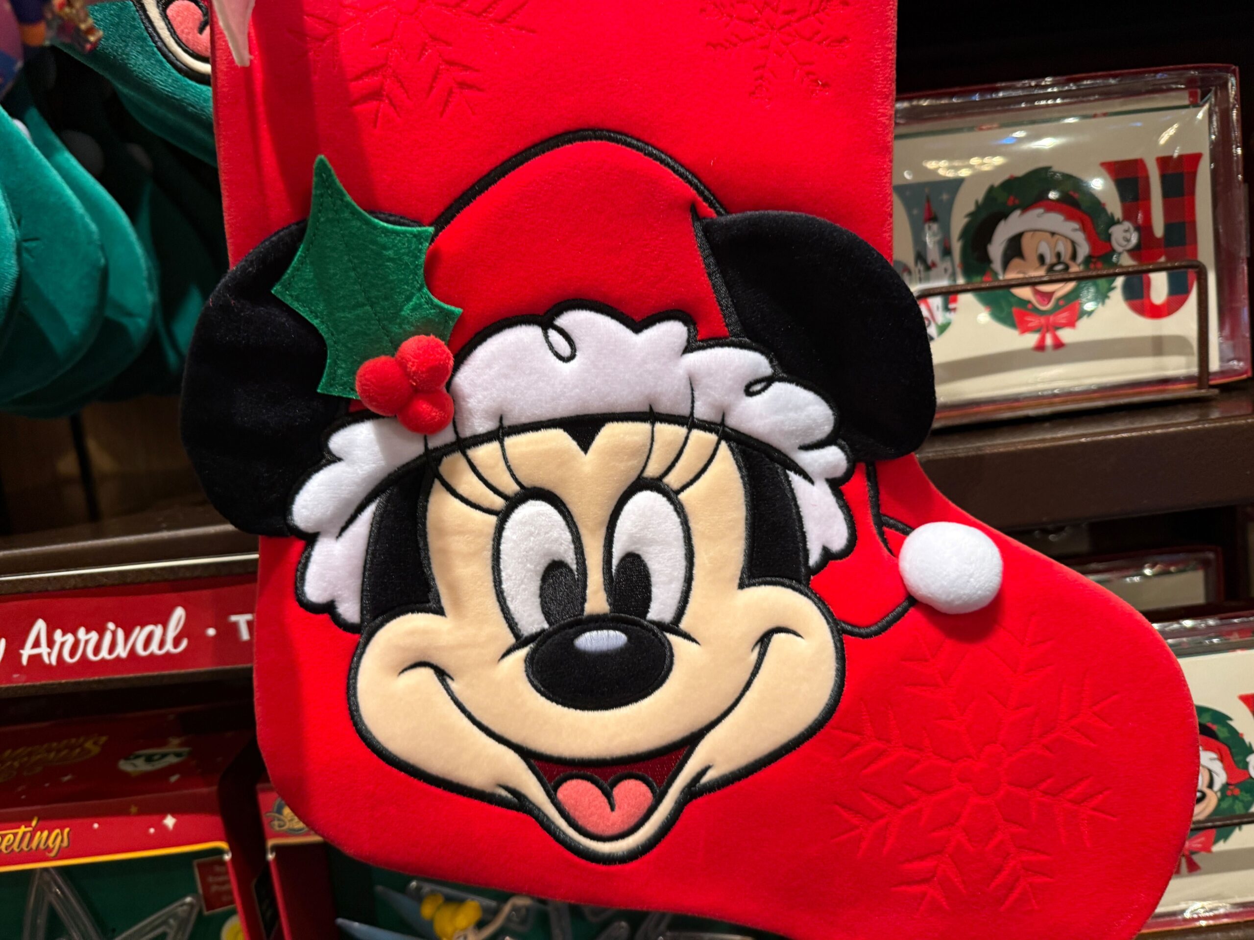 A red Christmas stocking from Walt Disney World 2025 featuring Minnie Mouse in a Santa hat and festive snowflake patterns.