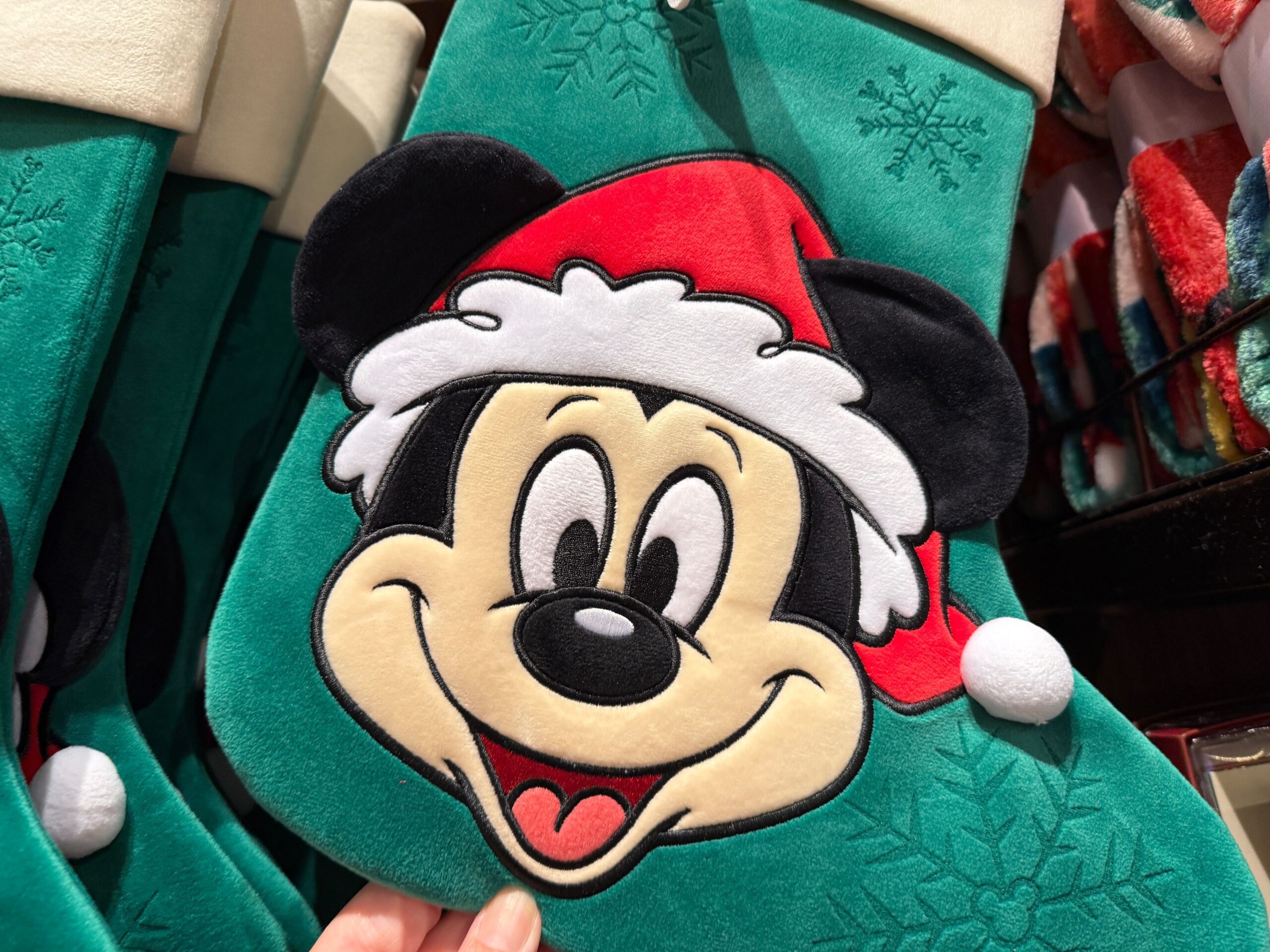 A green Christmas stocking featuring Mickey Mouse in a Santa hat—perfect 2025 Walt Disney World Christmas merchandise.