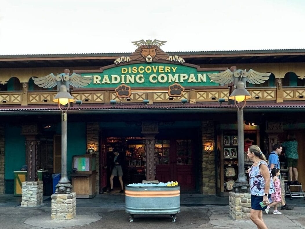 Front view of Discovery Trading Company at Walt Disney World; crowds outside, jackets displayed—no castle like those in Disney parks.