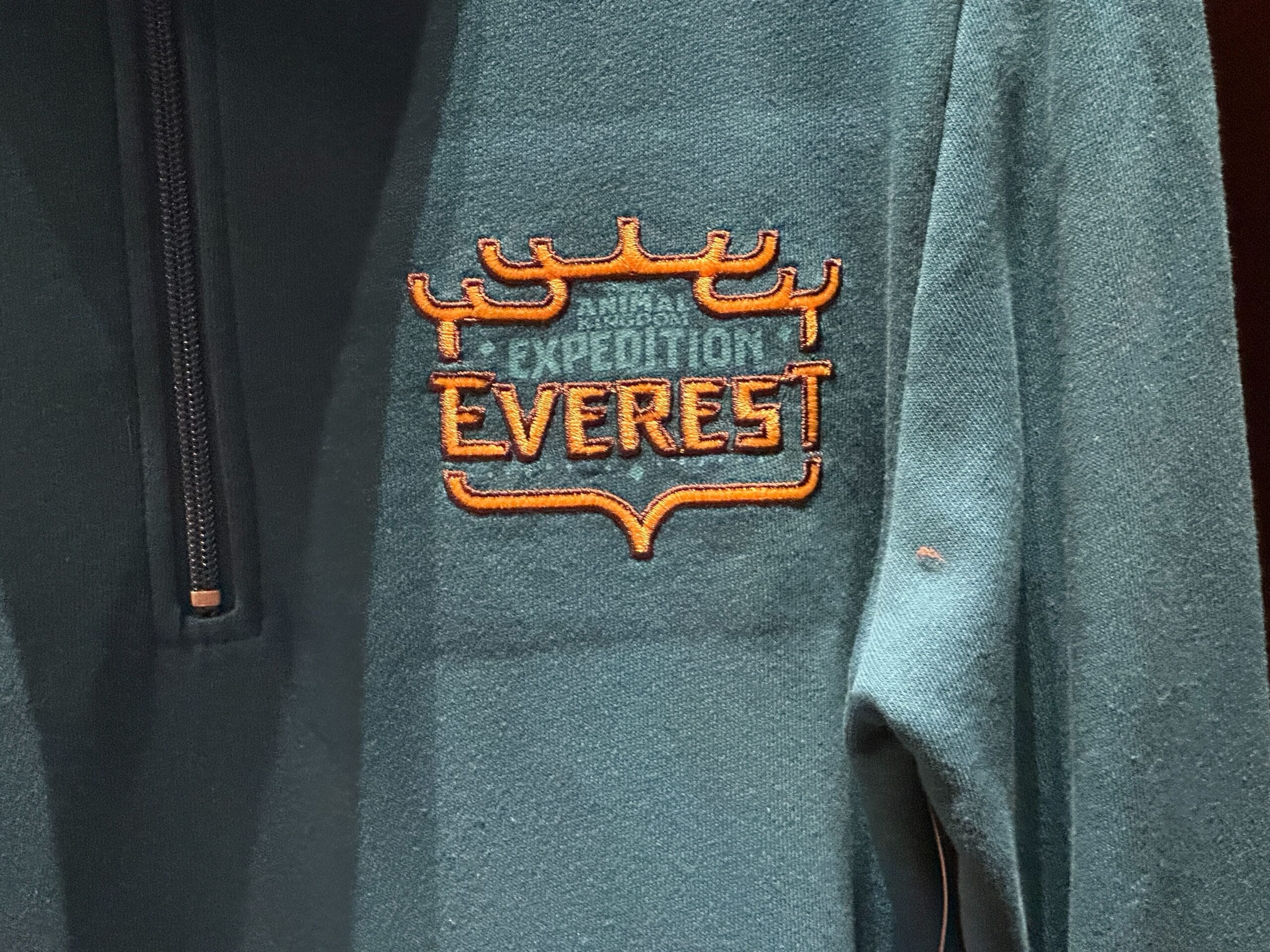 Dark green Disney parks jacket featuring the "Expedition Everest" logo and Surfer Yeti orange embroidery on the left chest.