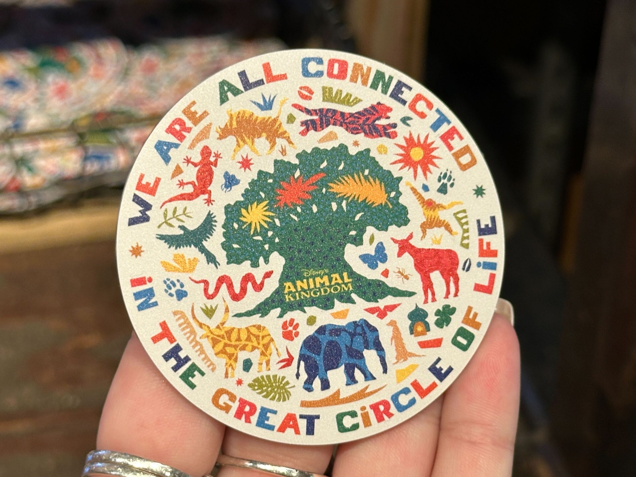 A round badge with animals encircling a tree, celebrating Disney’s Animal Kingdom; no castle imagery like other Disney parks.