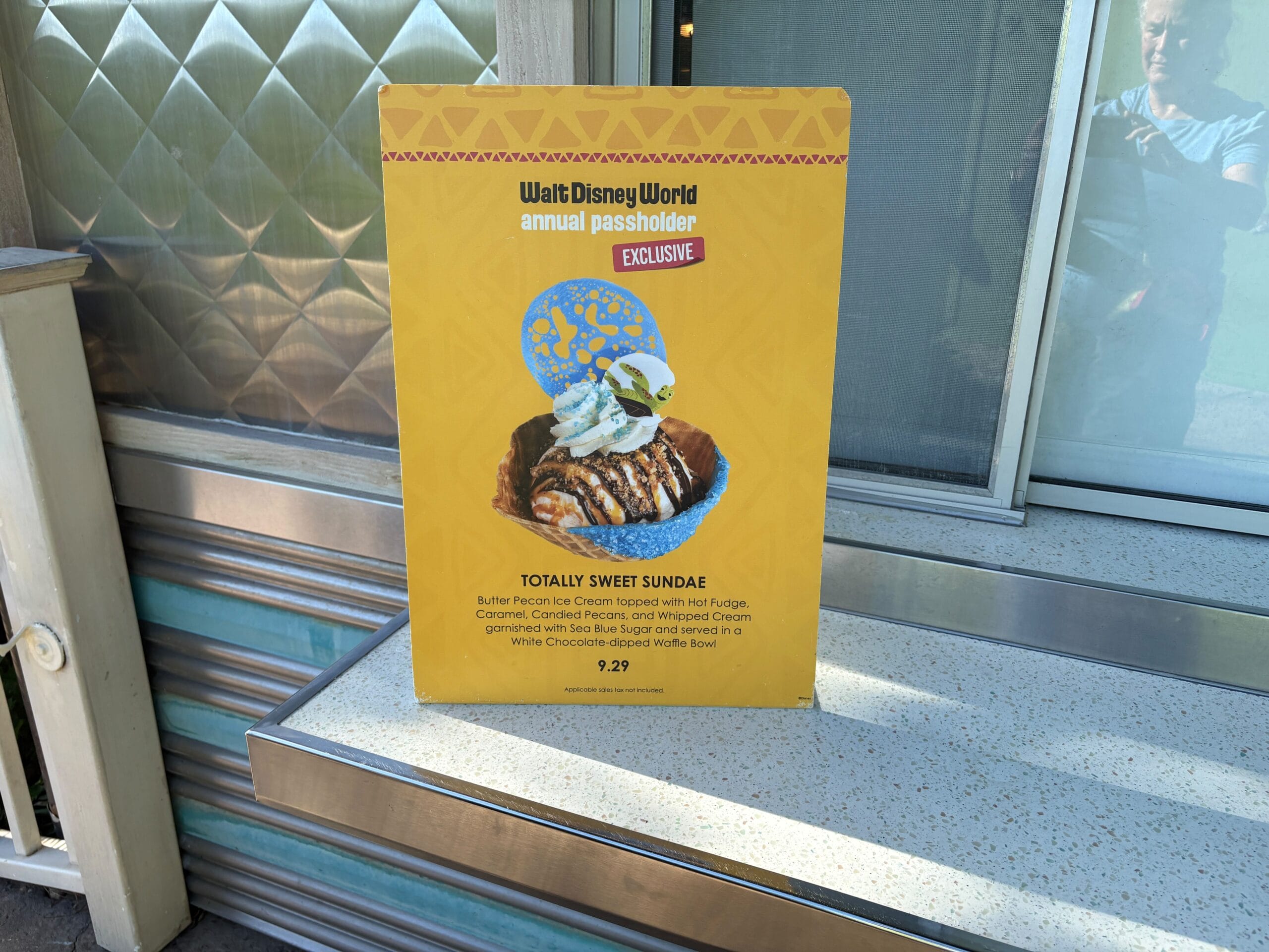 A sign at Dino Bite Snacks in Animal Kingdom advertises the Totally Sweet Sundae for passholders, priced at $9.29.