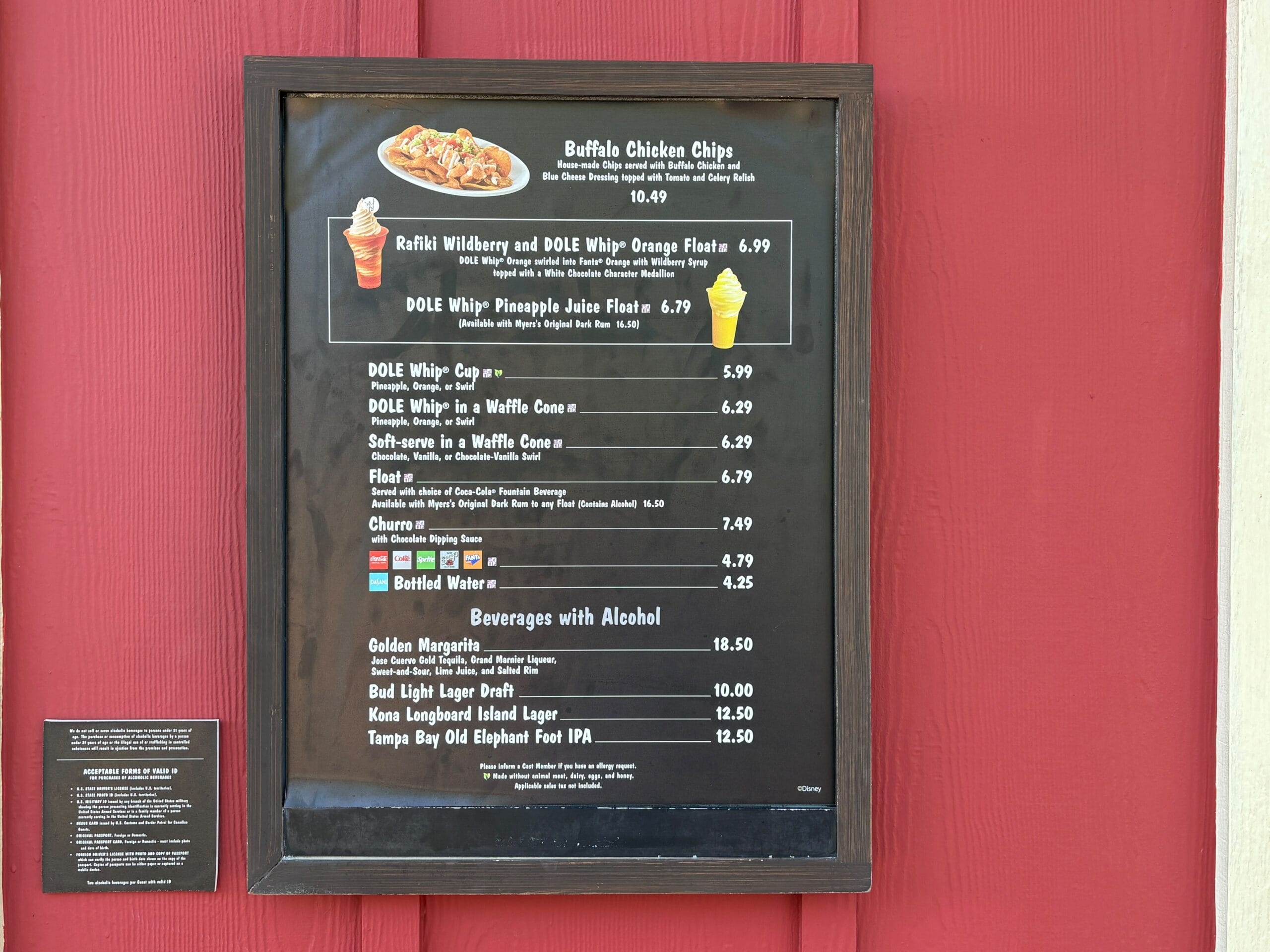 Trilo-Bites menu board on a red wall at Animal Kingdom, listing DOLE Whip, snacks, and drinks; no castle in view like Disney parks.