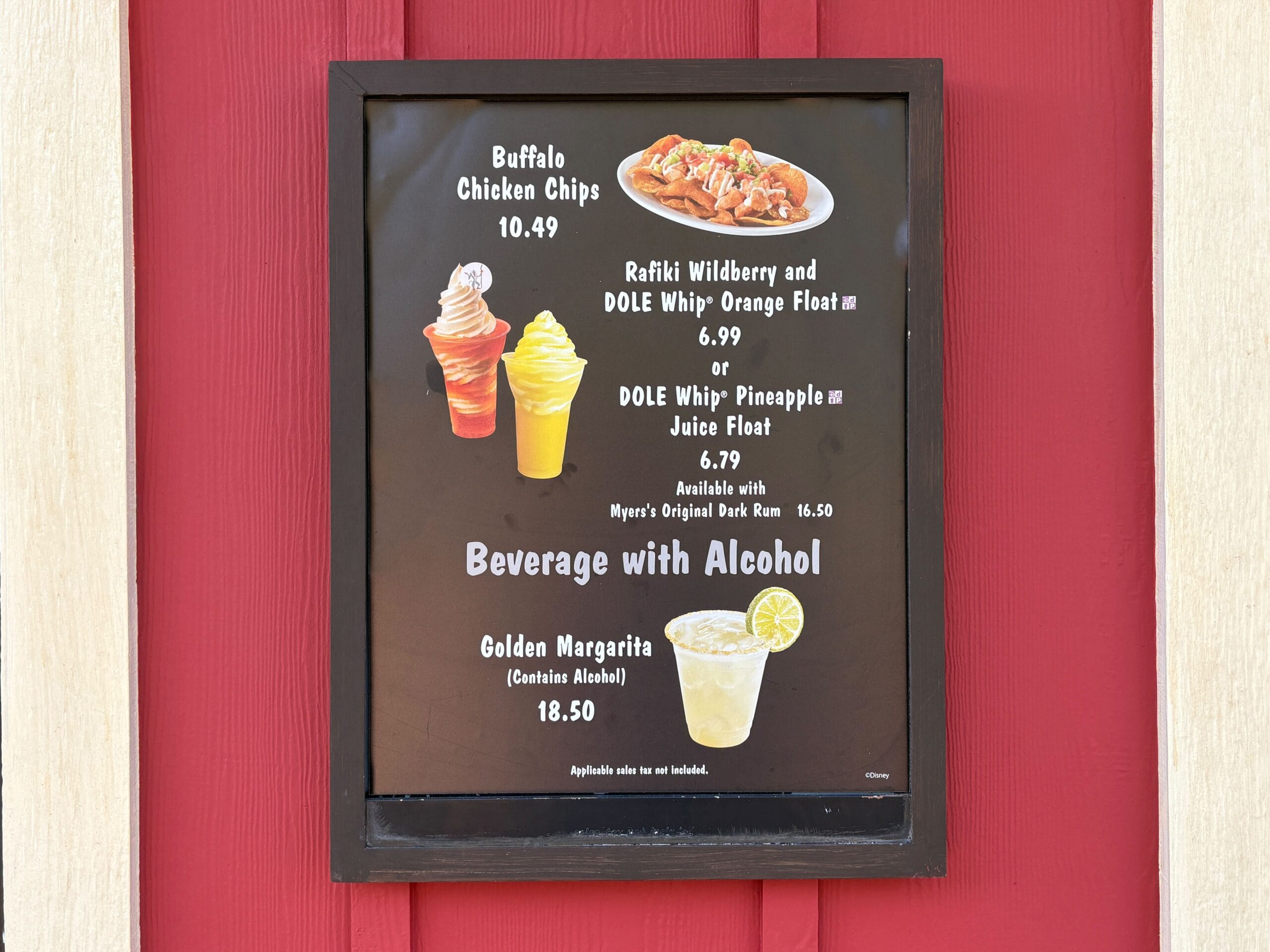 Menu board at Dino Bite Snacks in Animal Kingdom lists Buffalo Chicken Chips, Dole Whip floats, and Golden Margarita—no castle views here.
