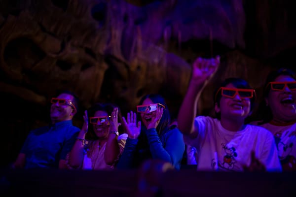 Guests in 3D glasses smile and cheer during a Disney Better Zoogether show, reminiscent of the immersive experiences at Disney Parks.