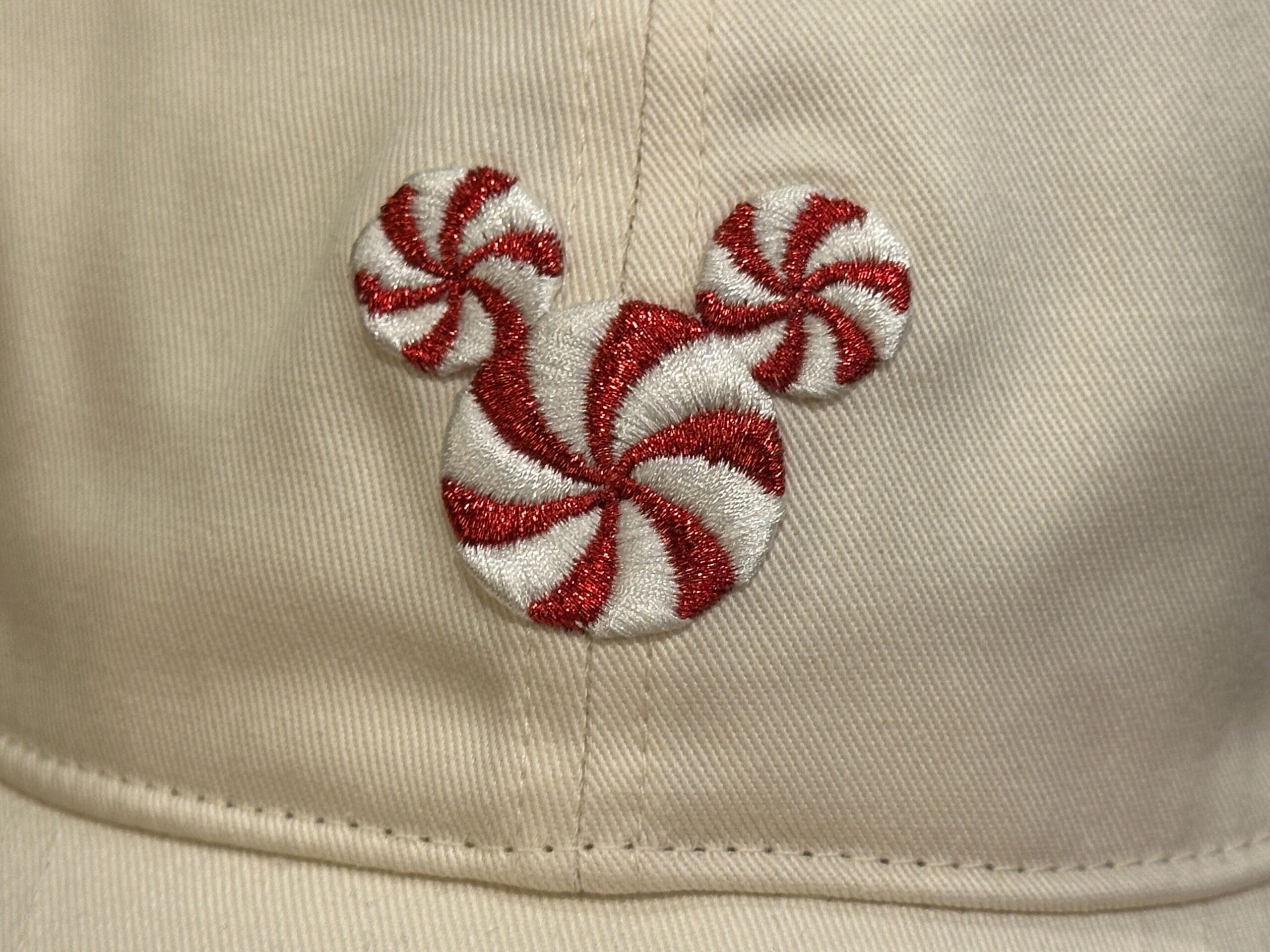 Beige hat featuring red and white peppermint Mickey Mouse, great for a Disney park visit
