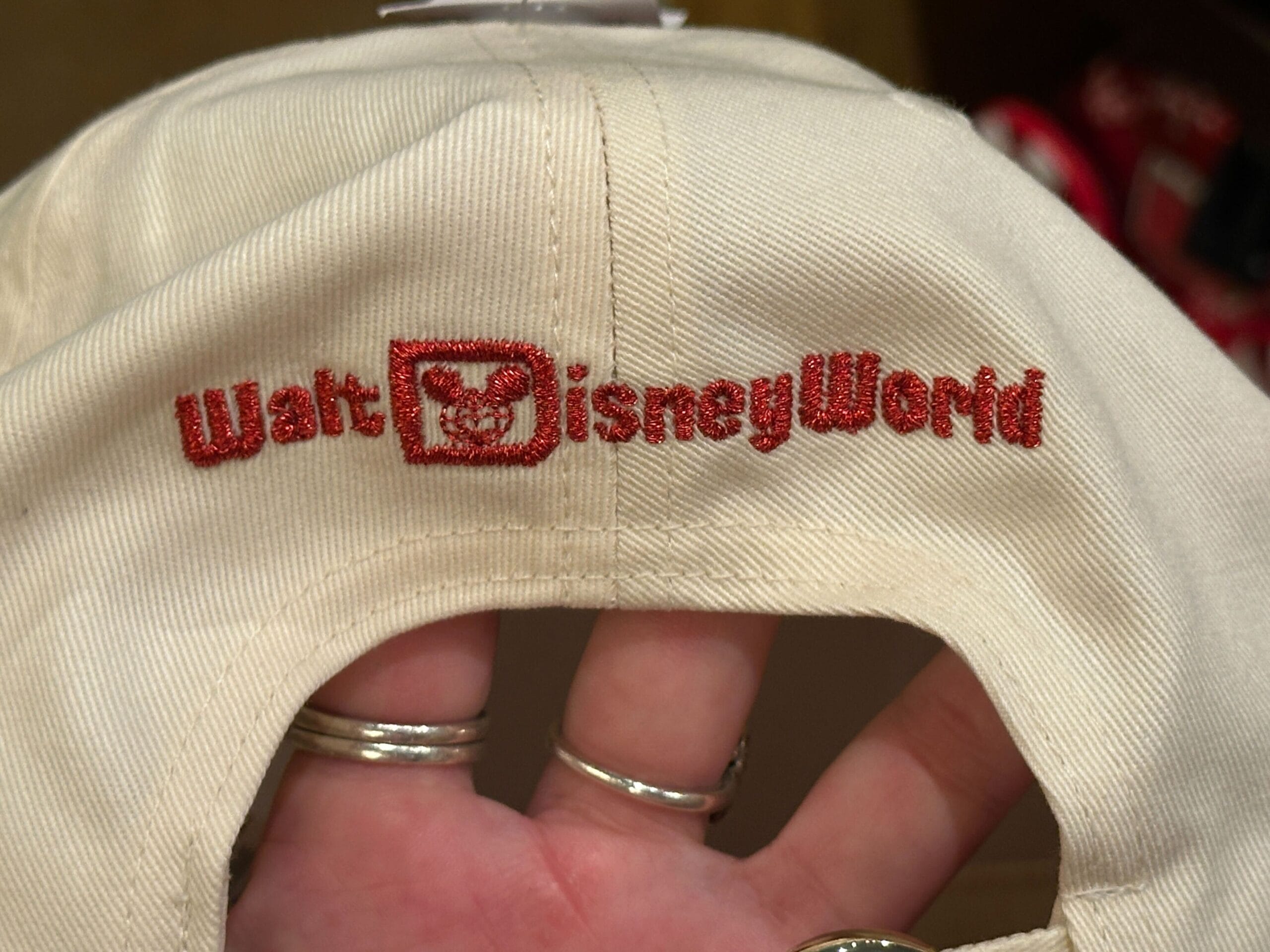 Beige hat with red "Walt Disney World" text and Mickey icon—pairs with holiday shirts; inspired by classic Magic Kingdom style.
