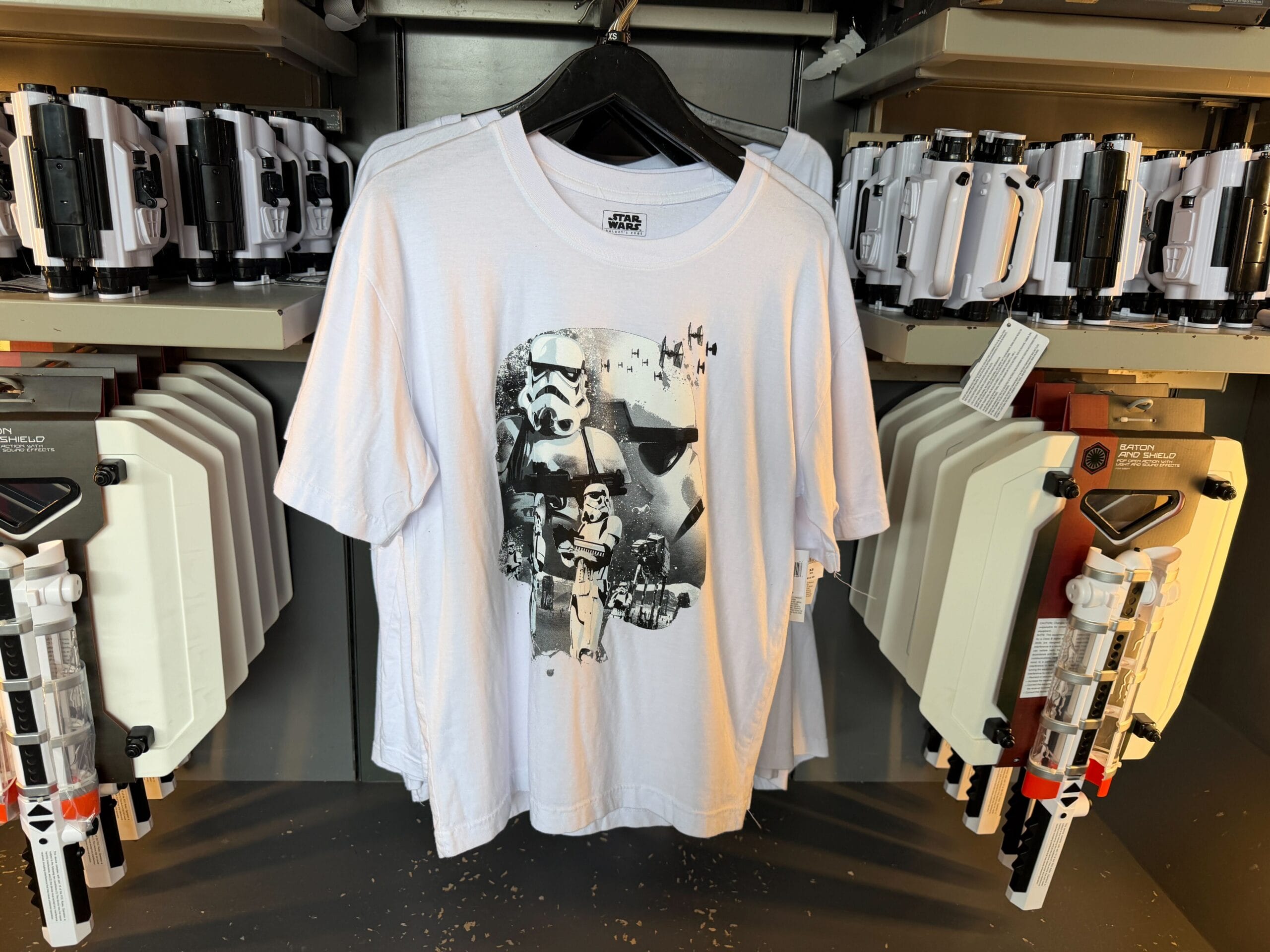 White Star Wars t-shirt with stormtrooper design on a rack, toy blasters nearby—typical merch at Disney’s Hollywood Studios.