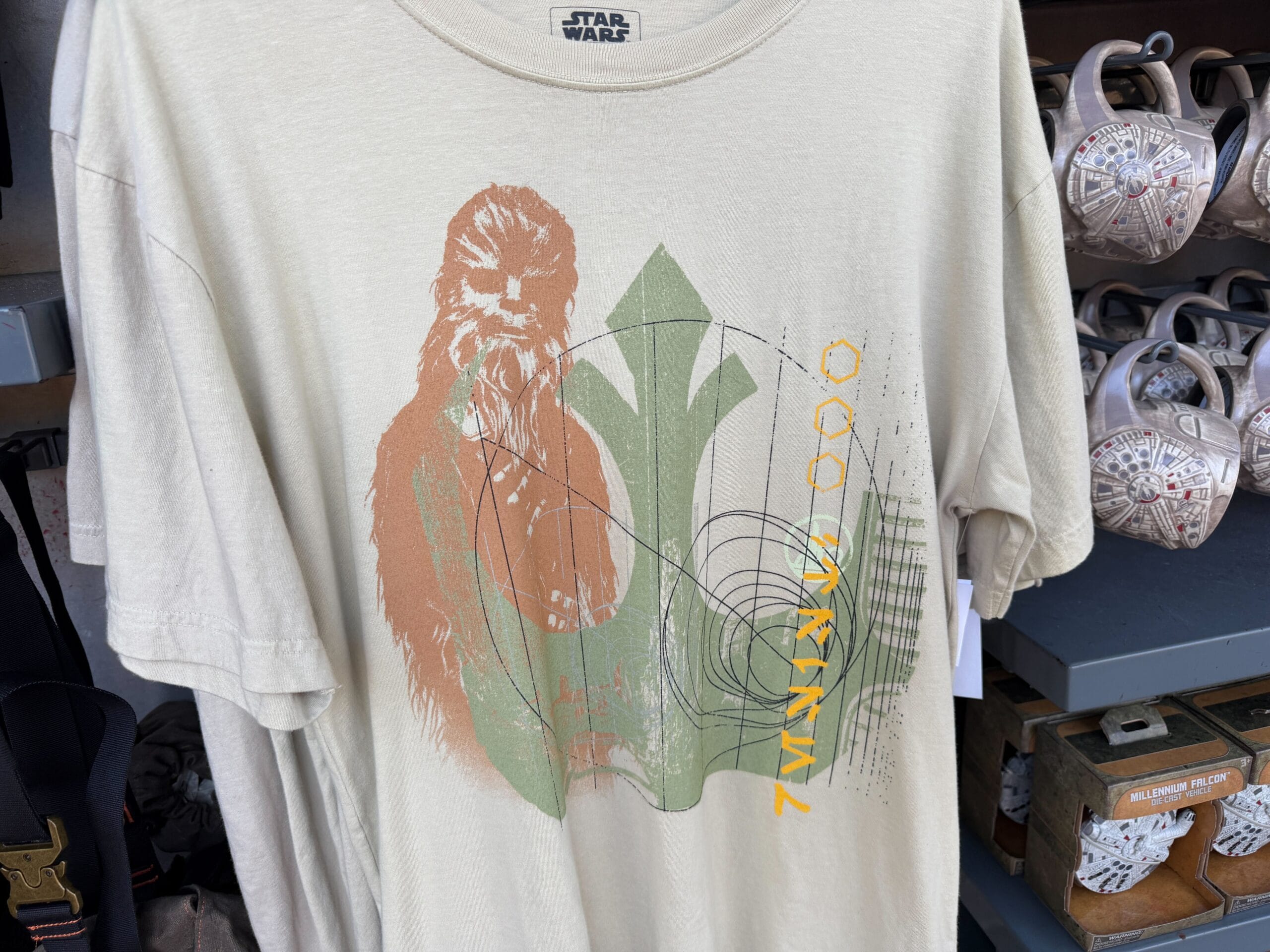 Beige Star Wars tee with Chewbacca graphic and "ARRWWW" in yellow, seen at a Disney park