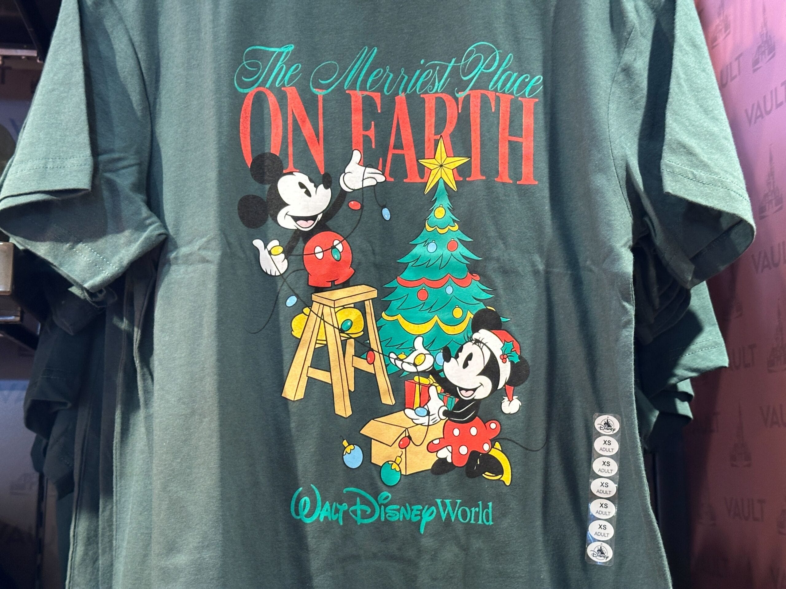 Green Holiday Tee with Mickey and Minnie decorating a Christmas tree at Disney World, reminiscent of Magic Kingdom’s festive style.