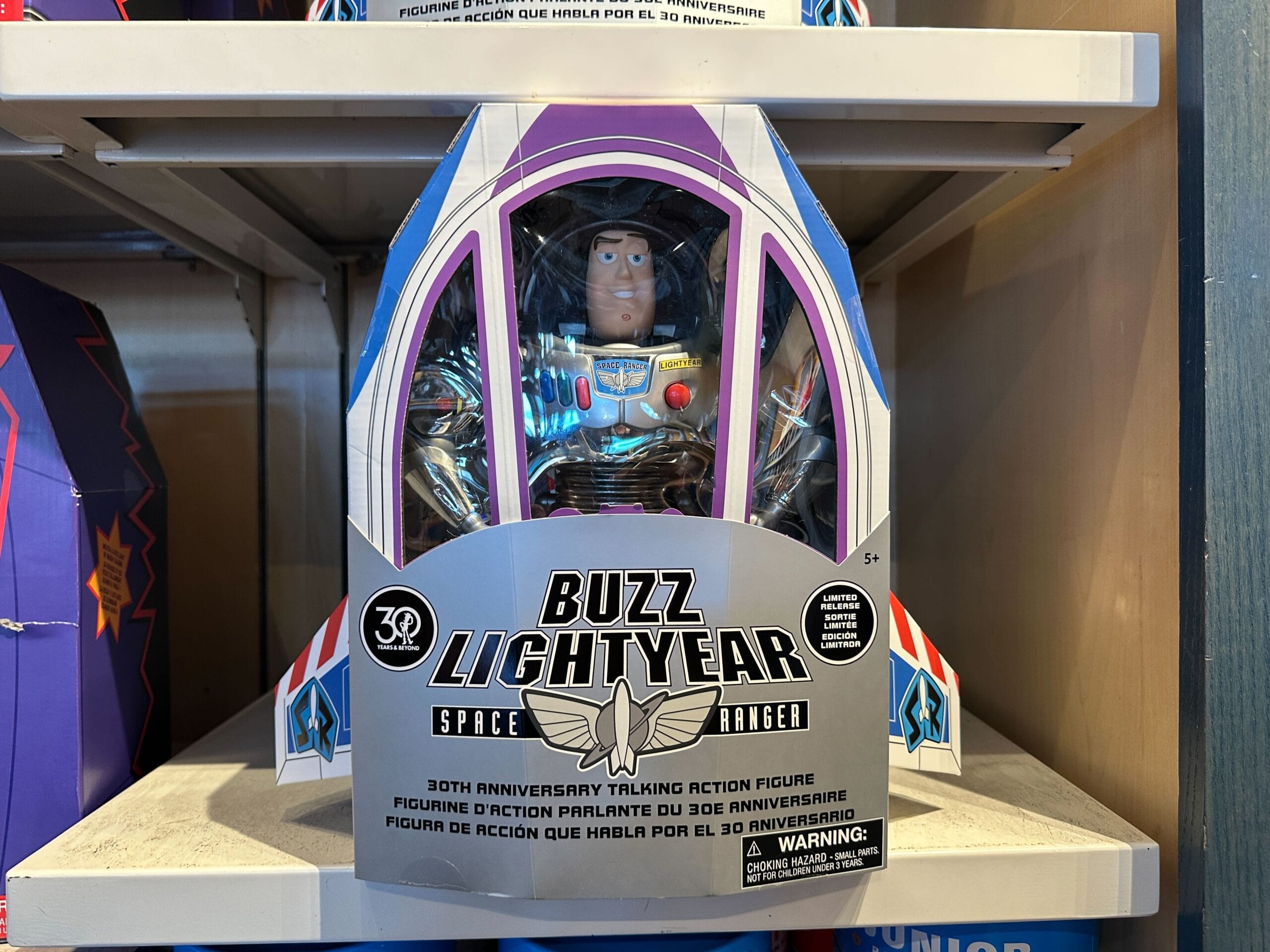 A Buzz Lightyear figure in a spaceship box on a shelf, honoring Toy Story’s 30th Anniversary, just like park displays at Disney.