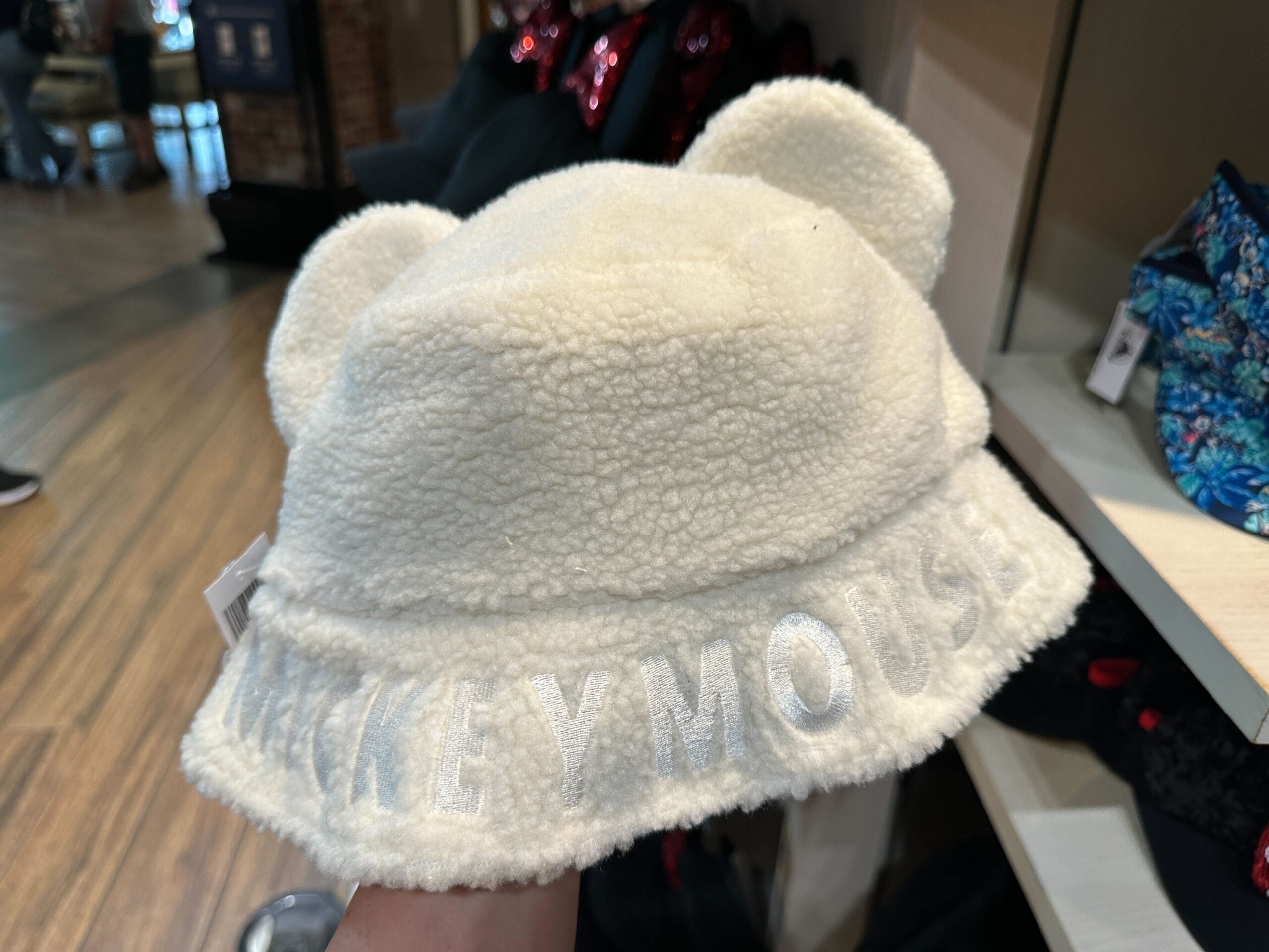 Soft white Mickey Mouse Sherpa hat with bear ears and “MICKEY MOUSE” brim, ideal for chilly days at any Disney park worldwide.