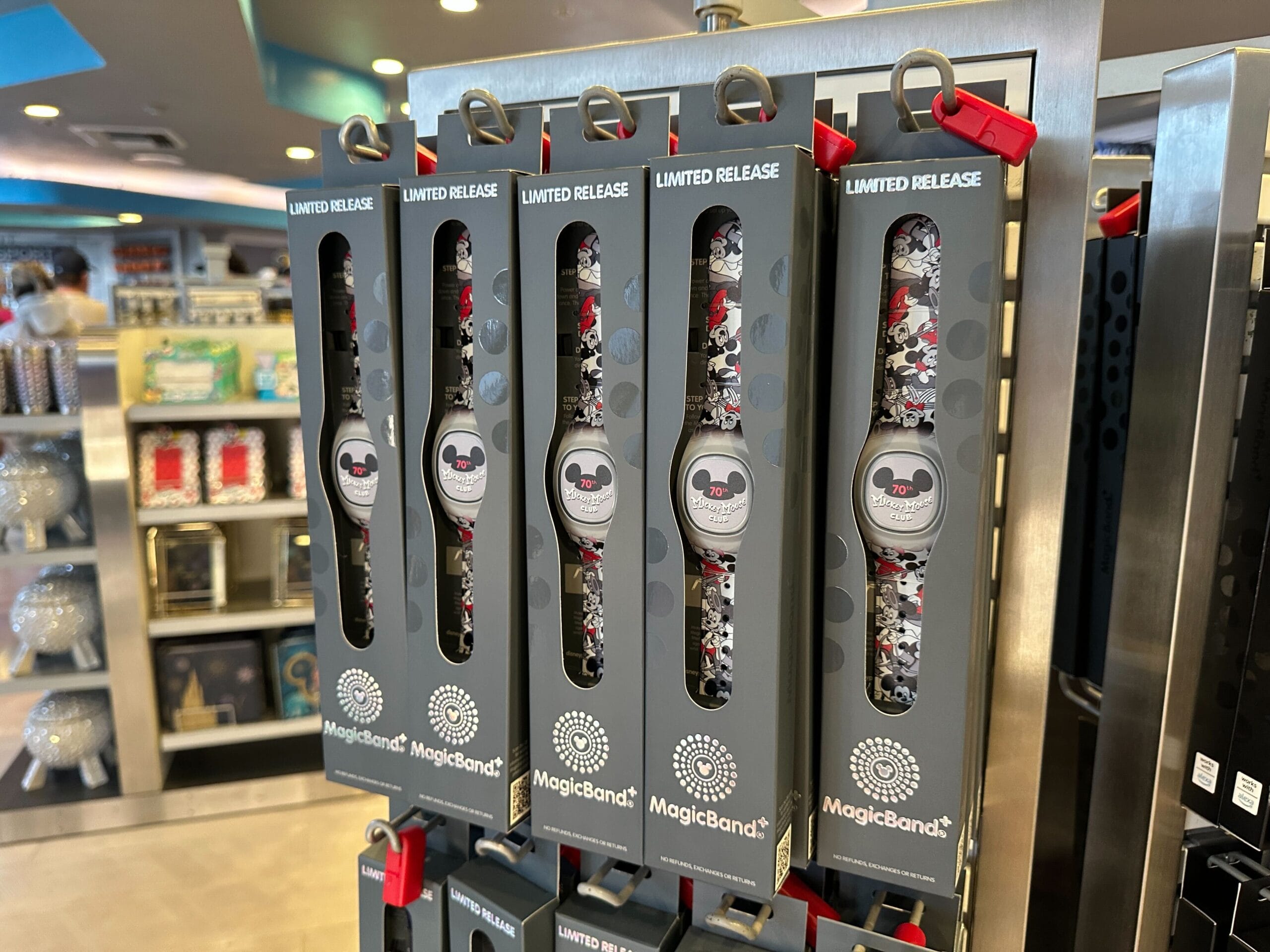 Limited release Disney MagicBand+ featuring Mickey Mouse Club is displayed in gray packaging on a store rack.