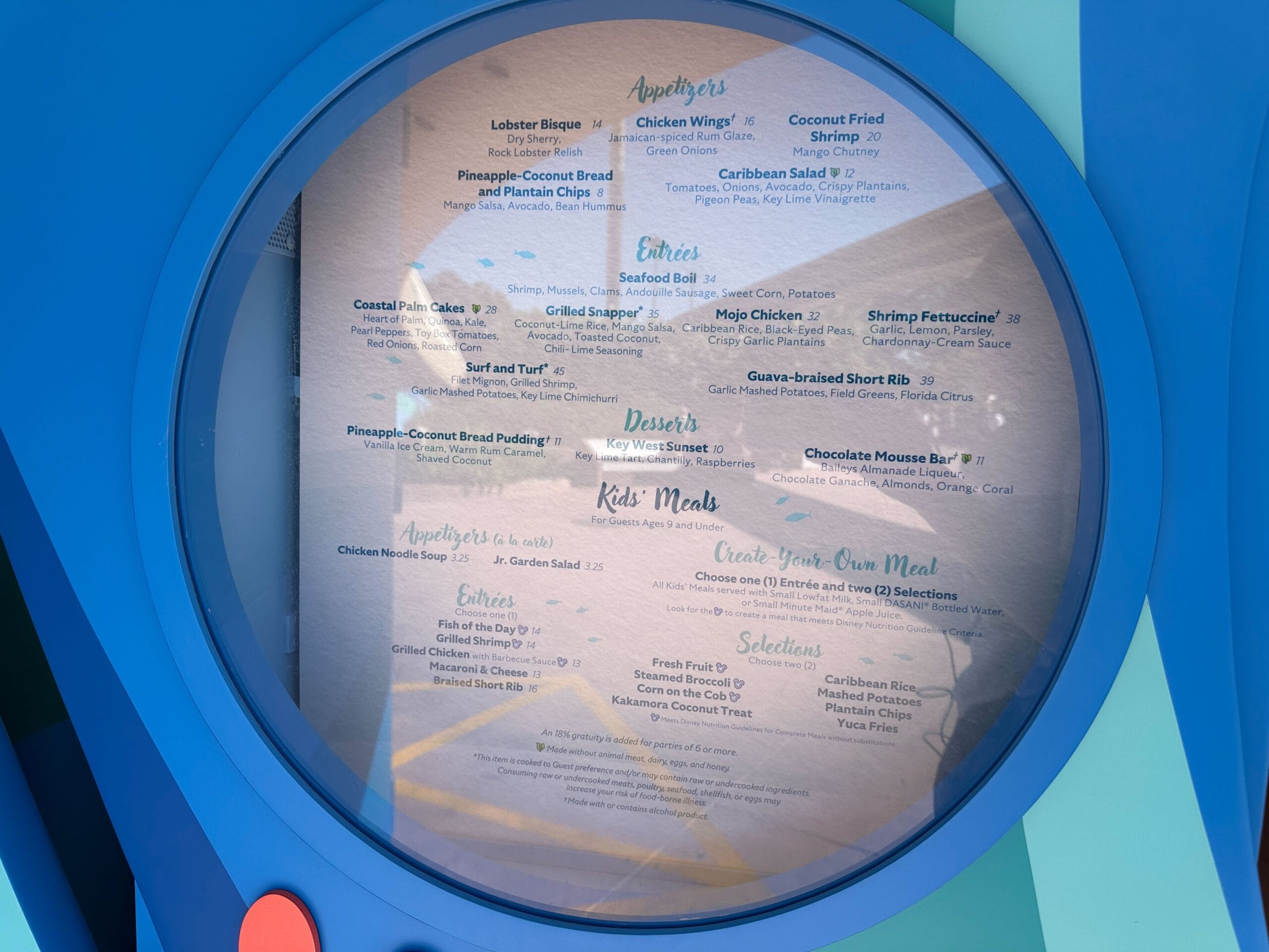 A vintage round Coral Reef menu from EPCOT Center in the 1980s, showing starters and desserts on wood—no castle like Magic Kingdom’s.