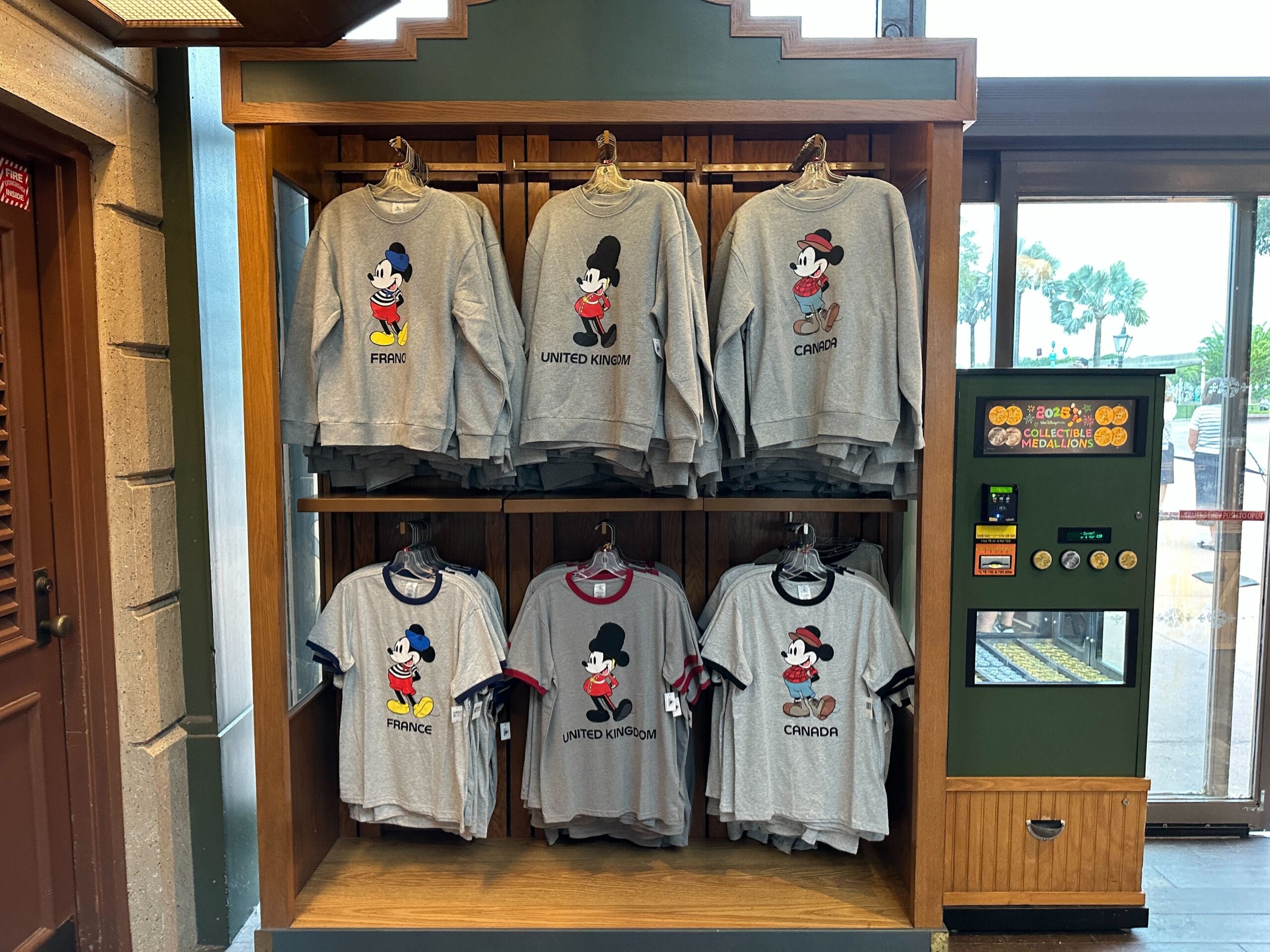 Gray Mickey Mouse shirts on display, inspired by EPCOT World Showcase Sweatshirt designs for France, UK, and Canada.