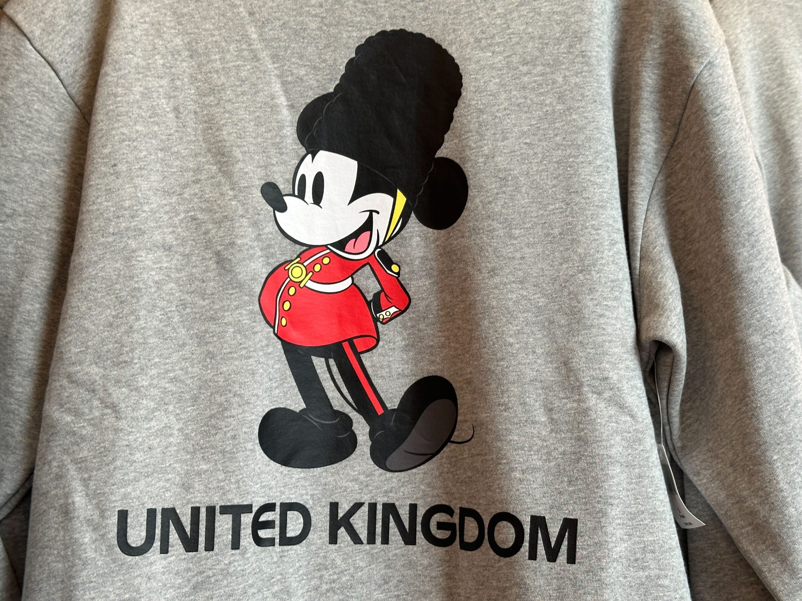 Part of the Sweatshirt Collection, this gray top features Mickey Mouse as a UK royal guard above "UNITED KINGDOM.