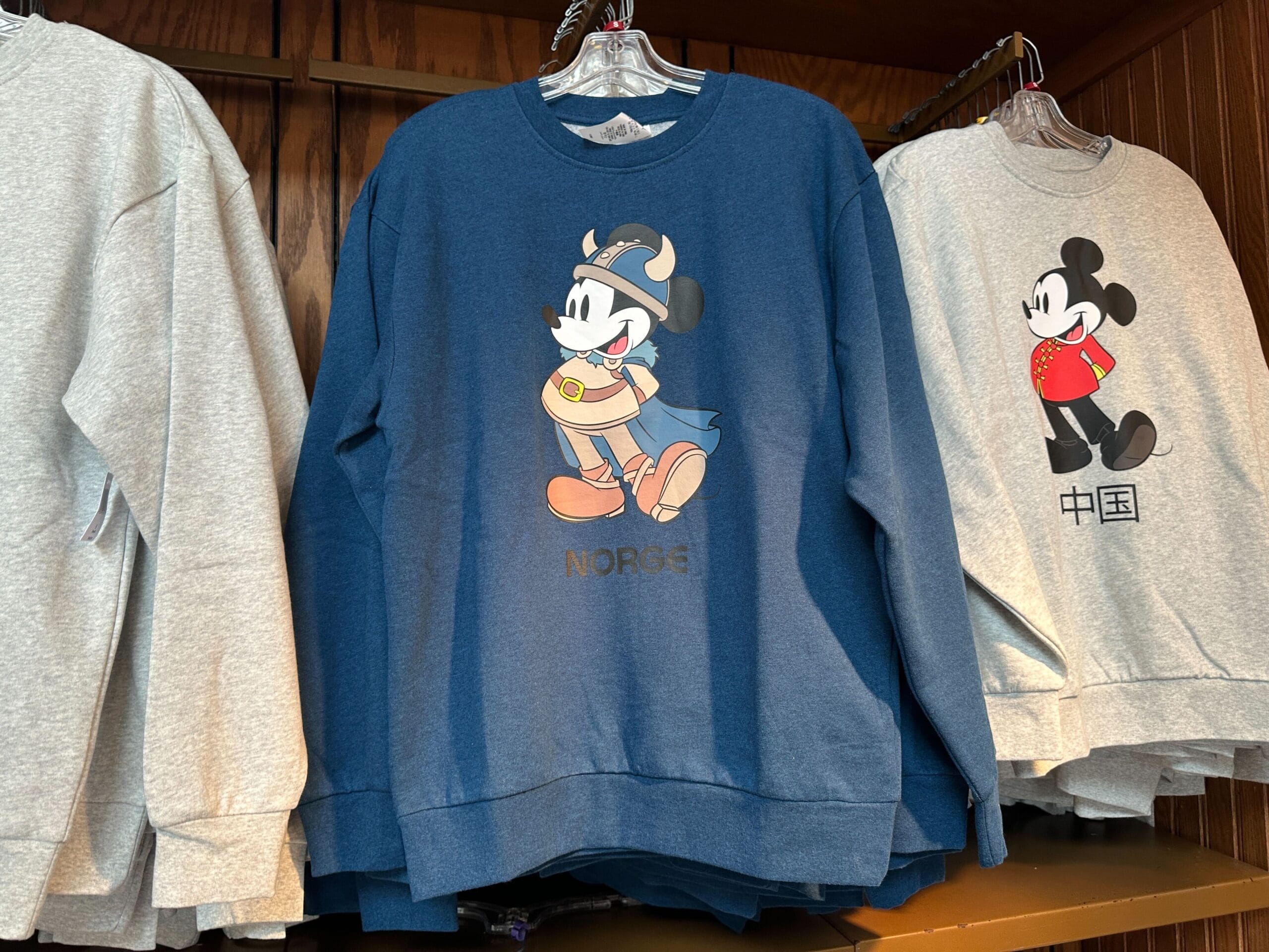 Sweatshirt Collection featuring Viking Mickey Mouse “NORGE” and EPCOT-inspired Mickey in red with Chinese writing.