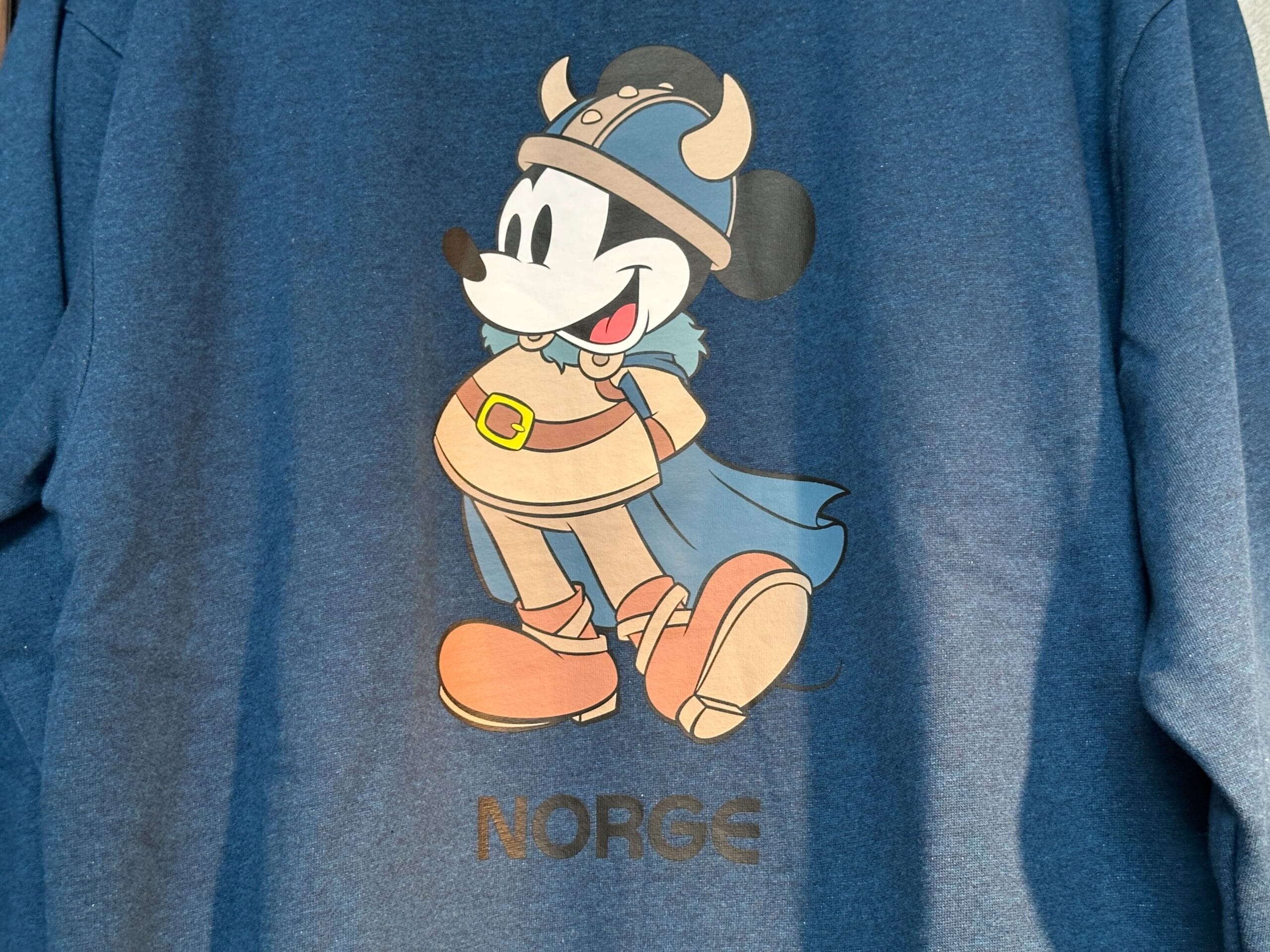 Mickey Mouse dressed as a Viking with a blue cape and helmet, above "Norge"—part of the EPCOT Sweatshirt Collection.