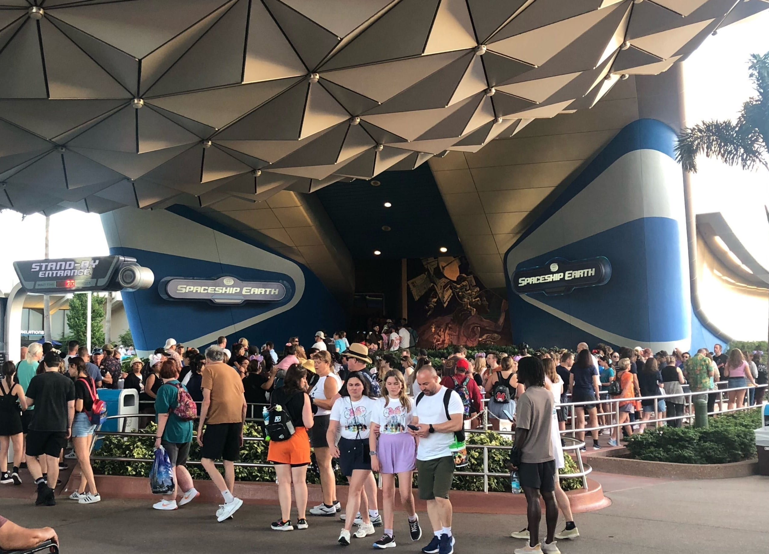 Guests gather by Spaceship Earth’s entrance as the iconic geodesic sphere at Epcot reopens after refurbishment; no castle pictured.