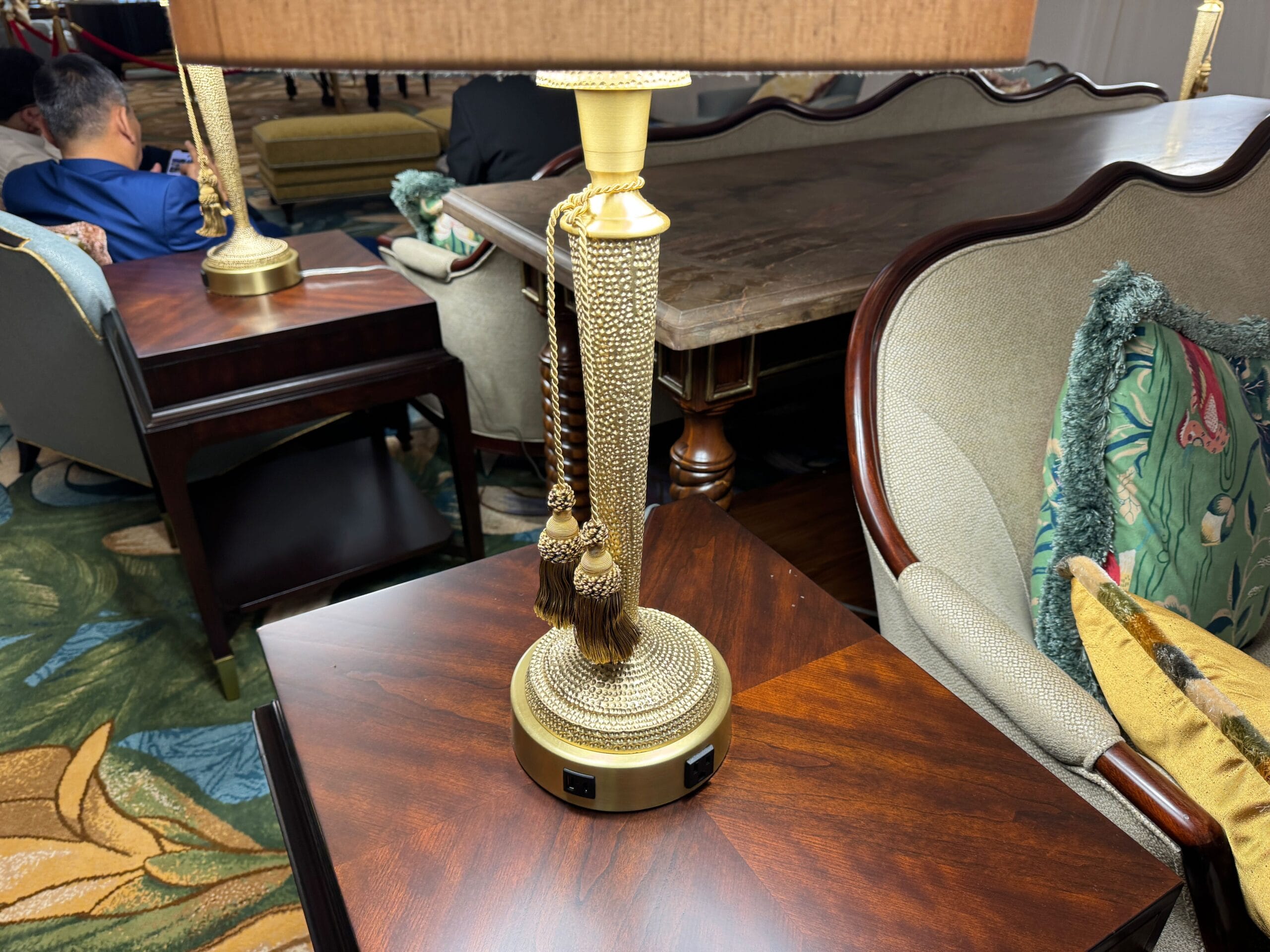 A gold lamp with tassels sits on a side table, reminiscent of Disney’s Grand Floridian Resort’s refined, Victorian-inspired décor.