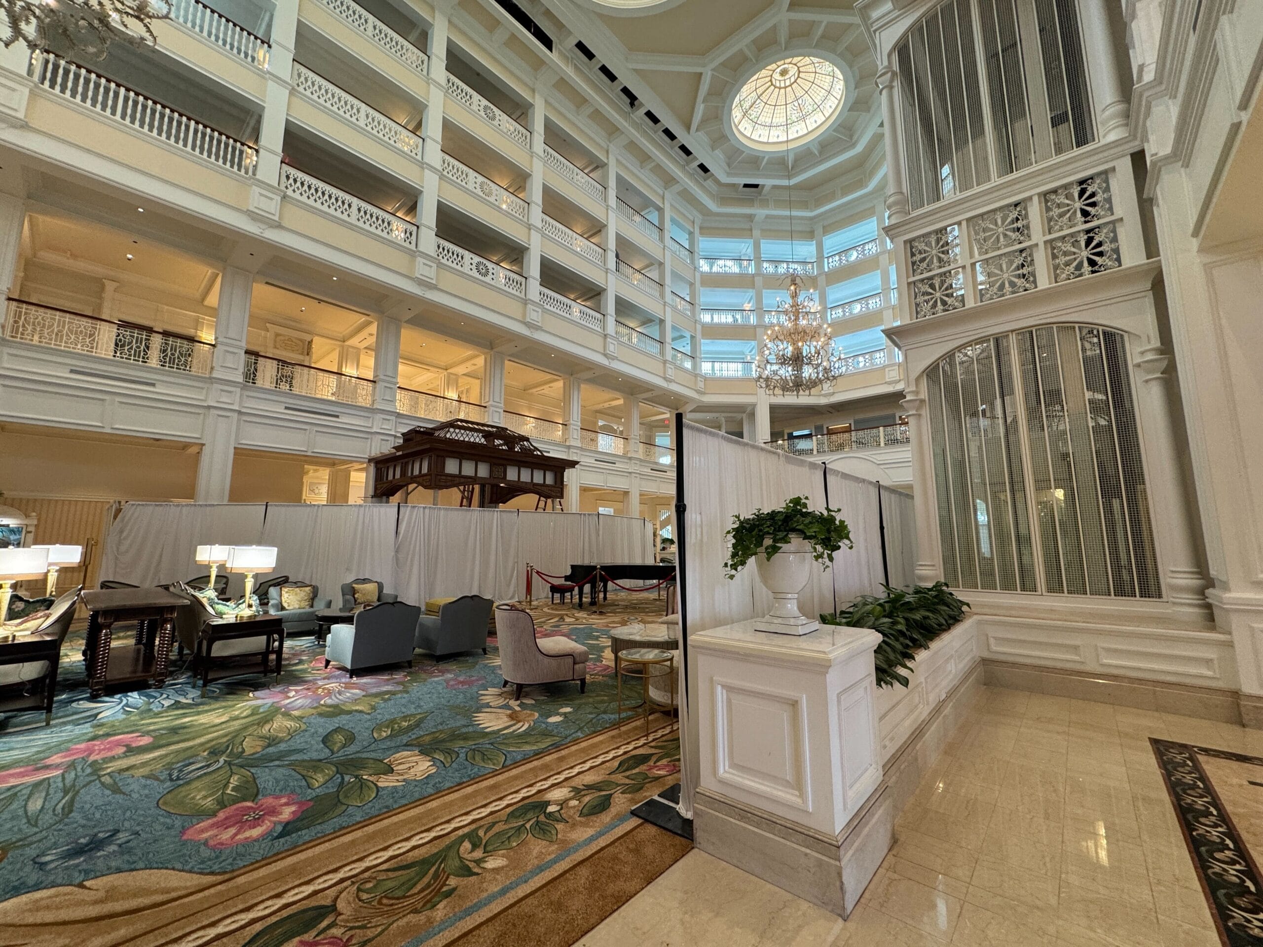 Grand Floridian Resort lobby after refurbishment, featuring soaring ceilings, grand chandeliers, elegant seating, and a floral carpet.