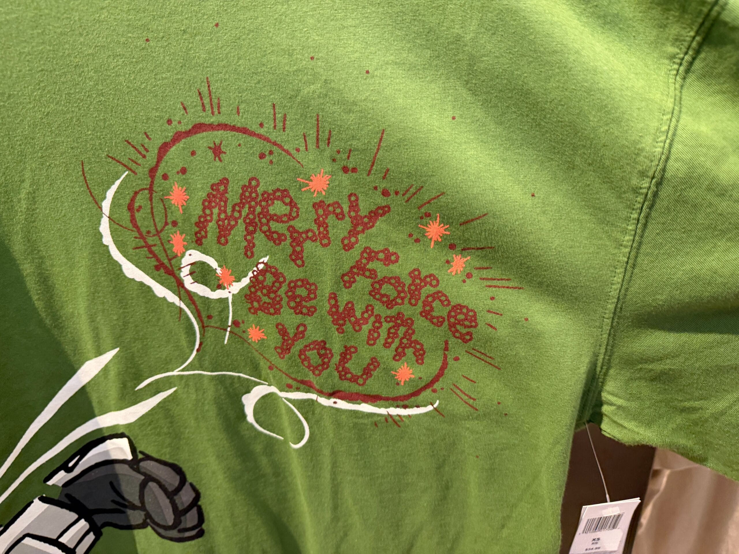 Green holiday tee with red sparkly "Merry Force Be With You"—ideal festive wear for Disney Parks fans, from Anaheim to Orlando.