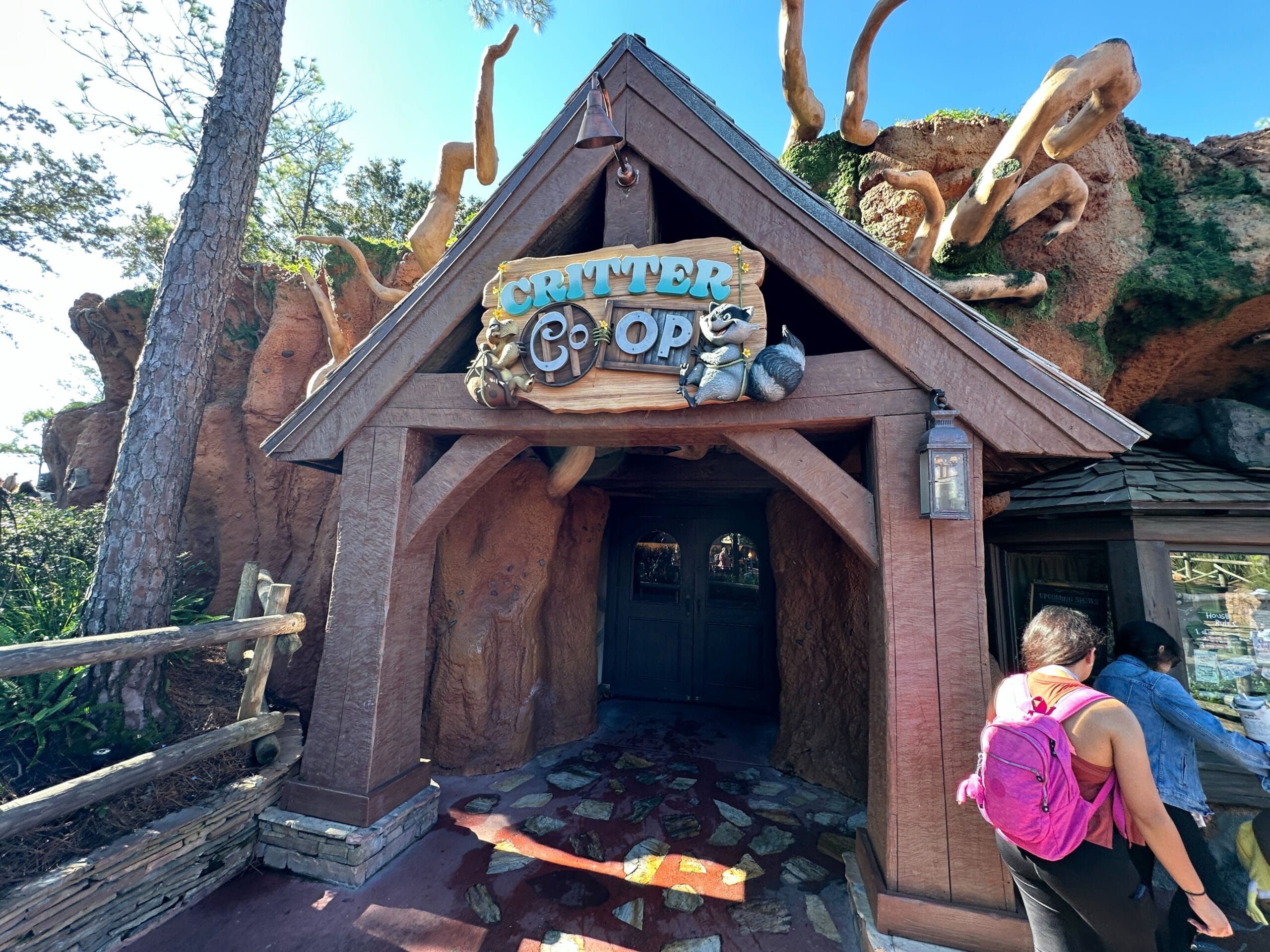 The Critter Co-Op shop’s wooden sign greets Disney World guests, sunshine highlighting the welcoming entrance—no castle in view.