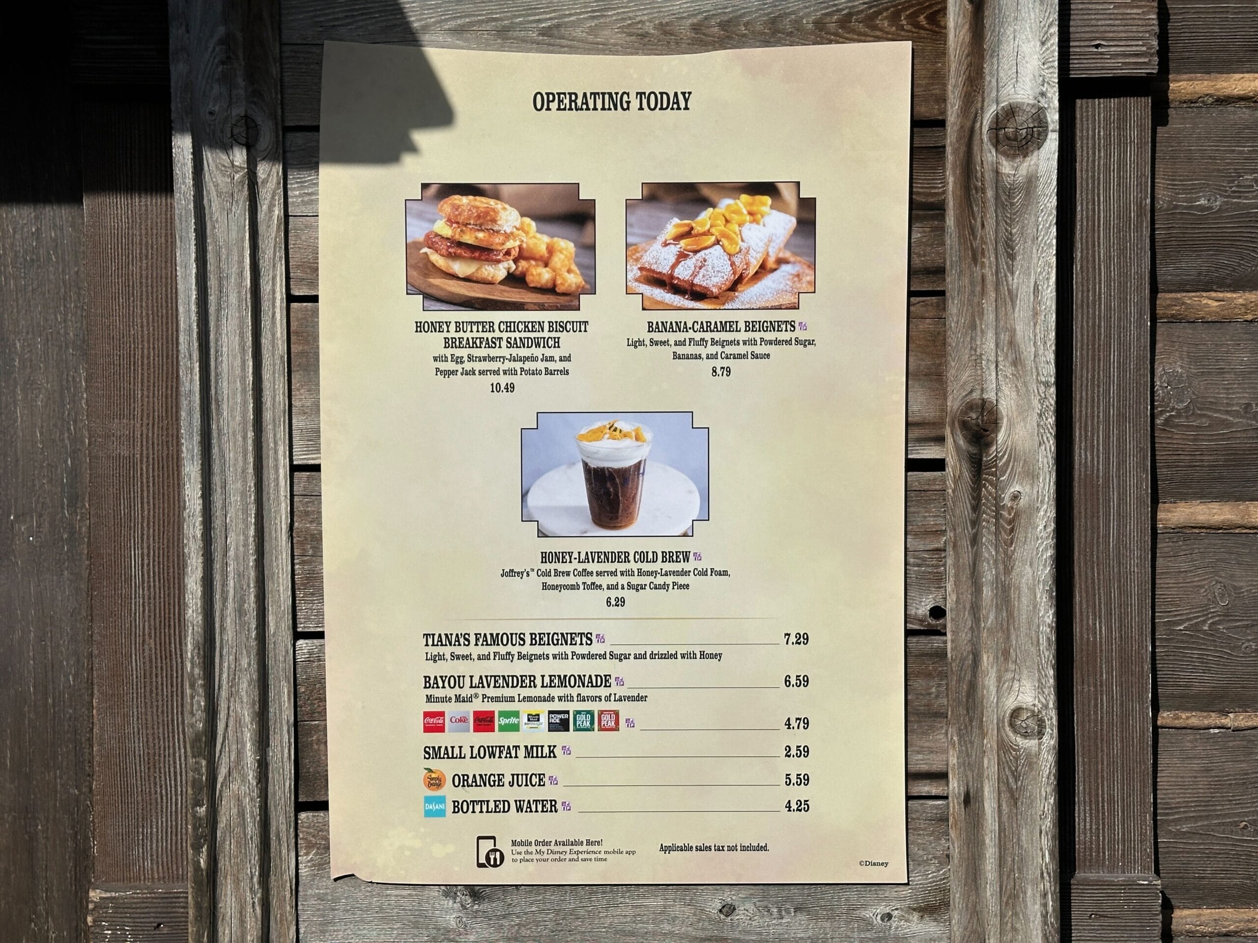 A wooden menu board spotlights the Honey-Lavender Cold Brew from Magic Kingdom—no Cinderella Castle, just a tempting drink special.
