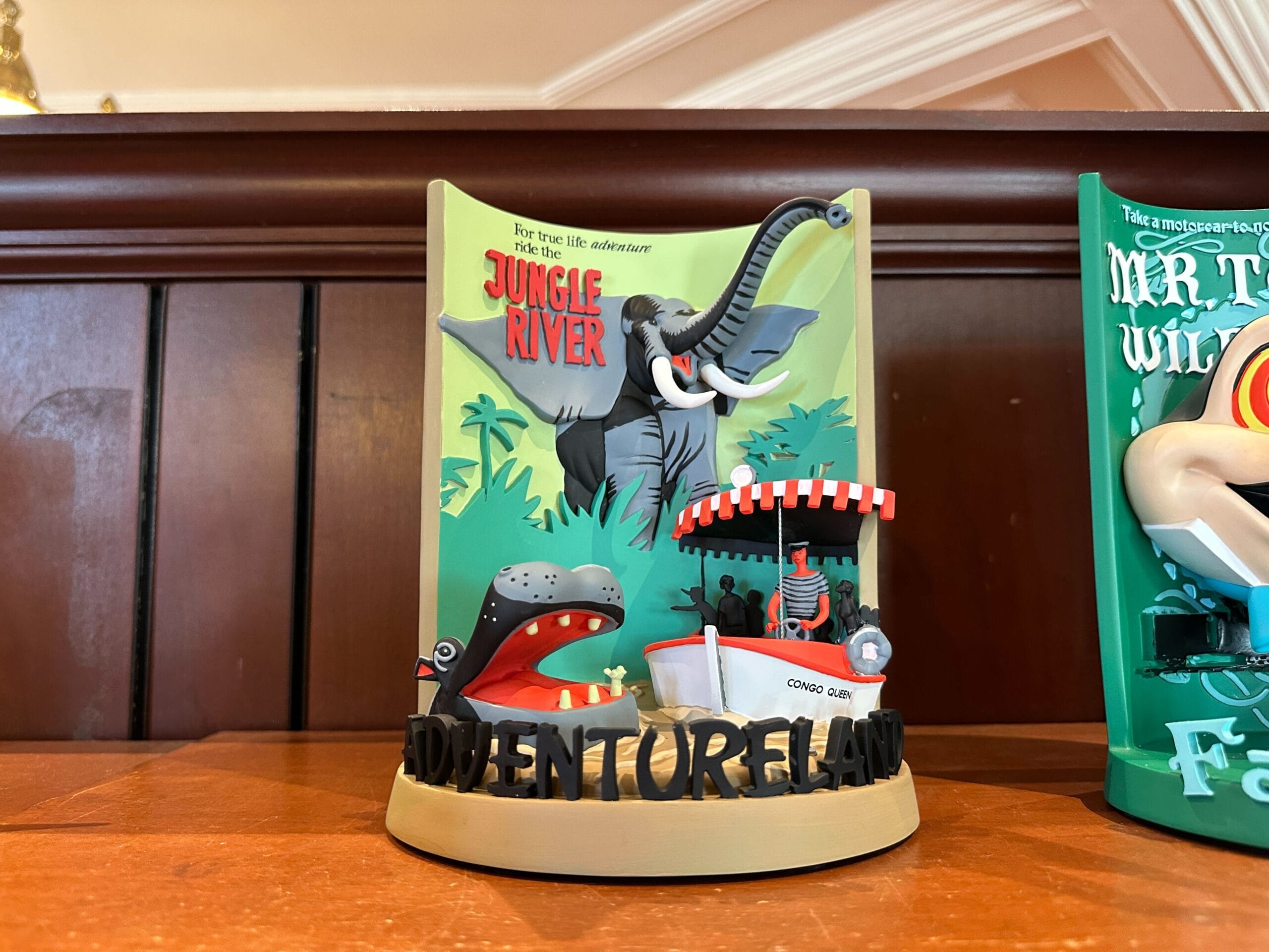 A Disney World Jungle Cruise 3-D figurine with an elephant, hippo, and boat labeled "Jungle River Adventureland.