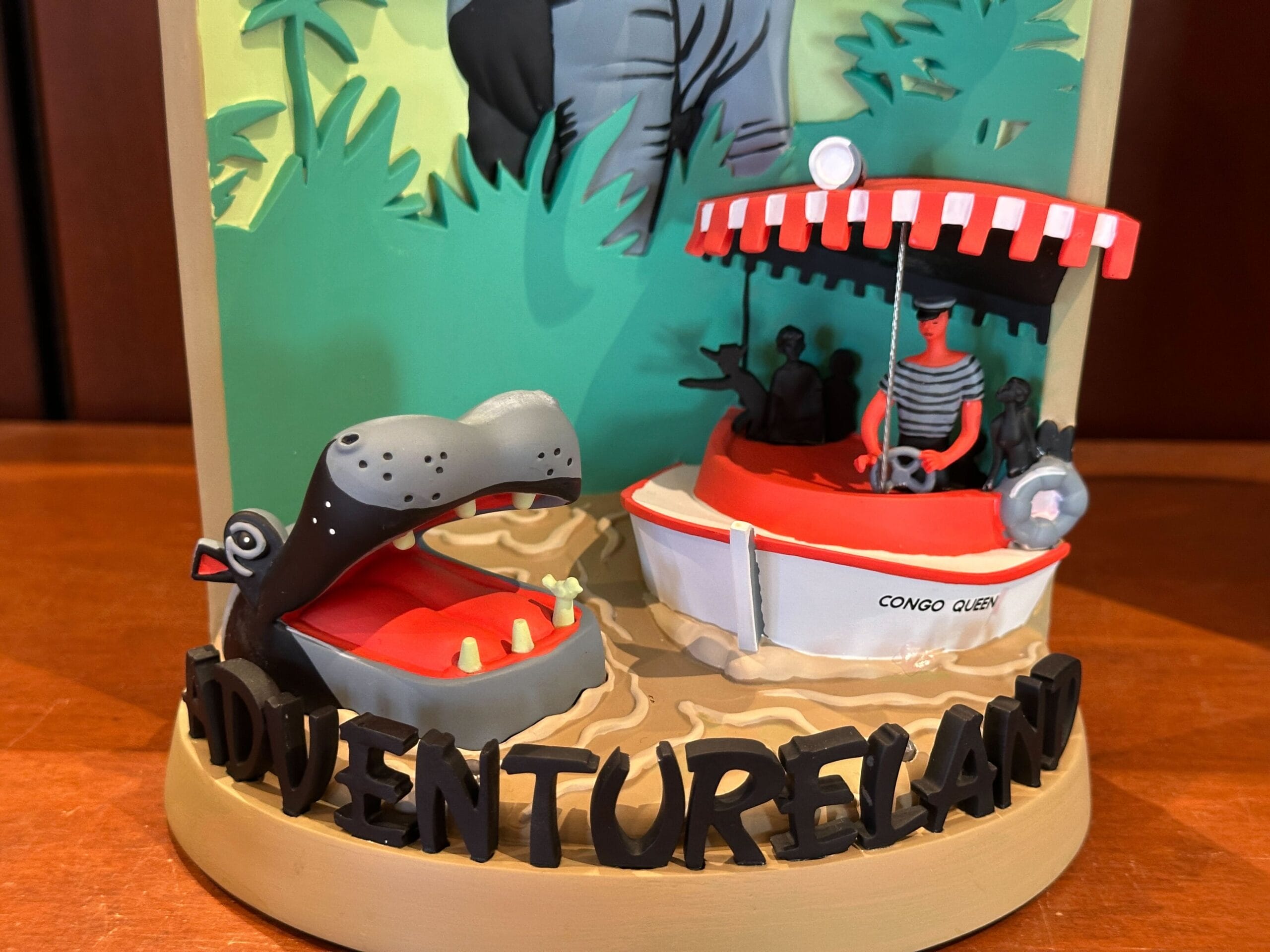 A 3-D figurine of the Jungle Cruise boat "Congo Queen" with a hippo and "ADVENTURELAND" at the base from Disney World.