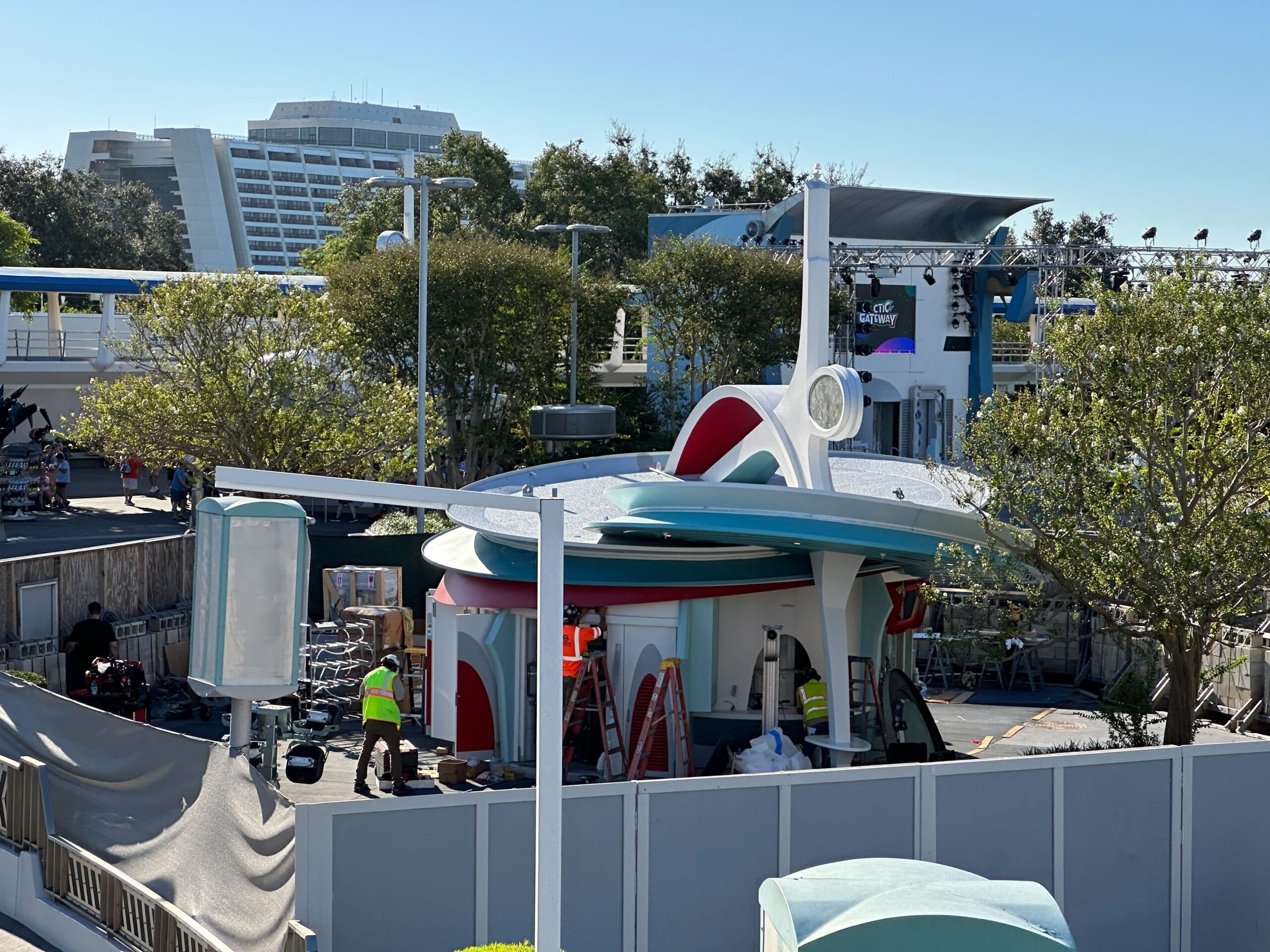 Construction workers and equipment surround the Cool Ship in Tomorrowland, fenced off like many Disney refurb zones; no castle visible.