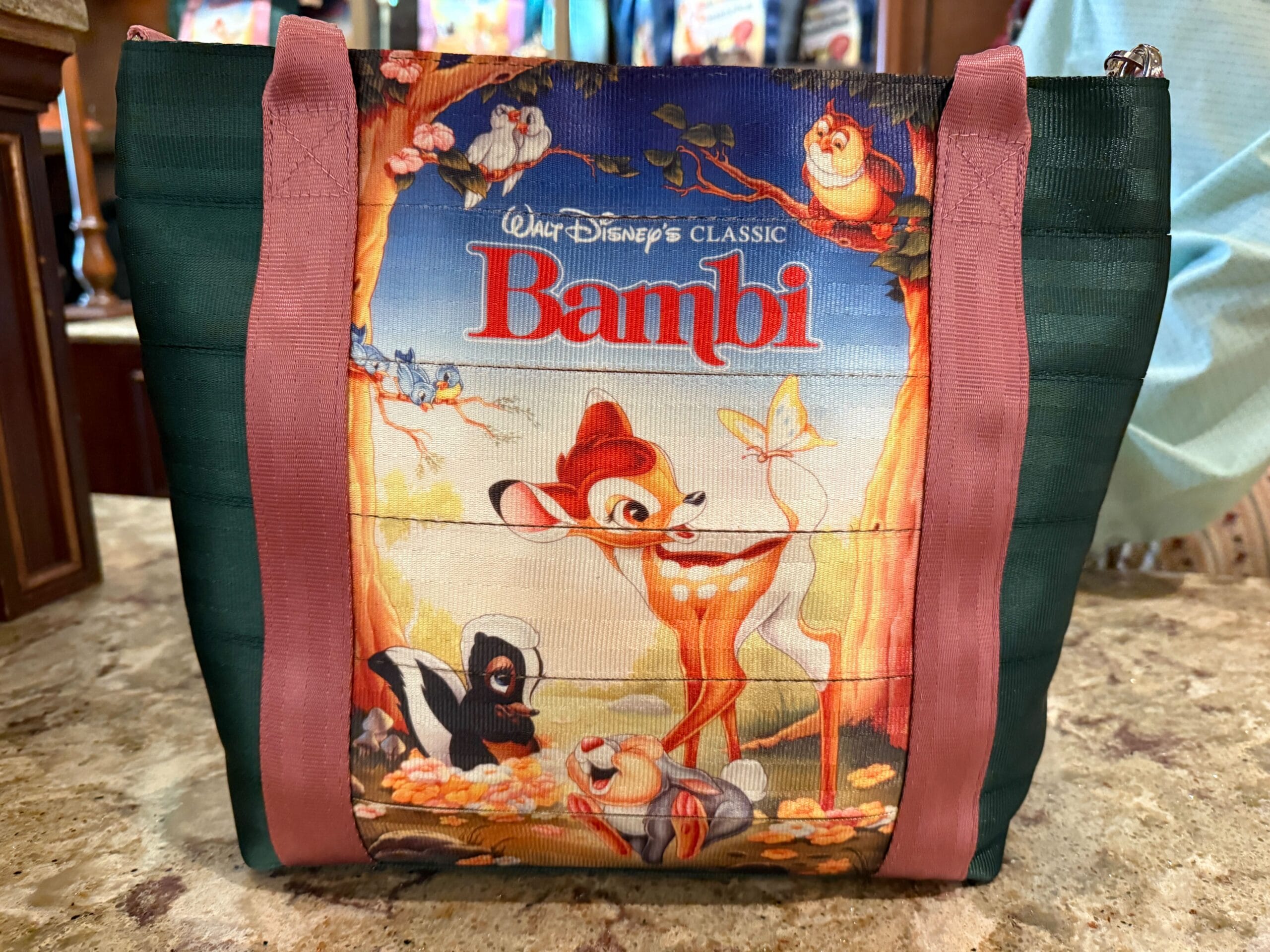 A Harvey Handbag tote from Disney Parks with Bambi and woodland friends, detailed with pink and green straps.