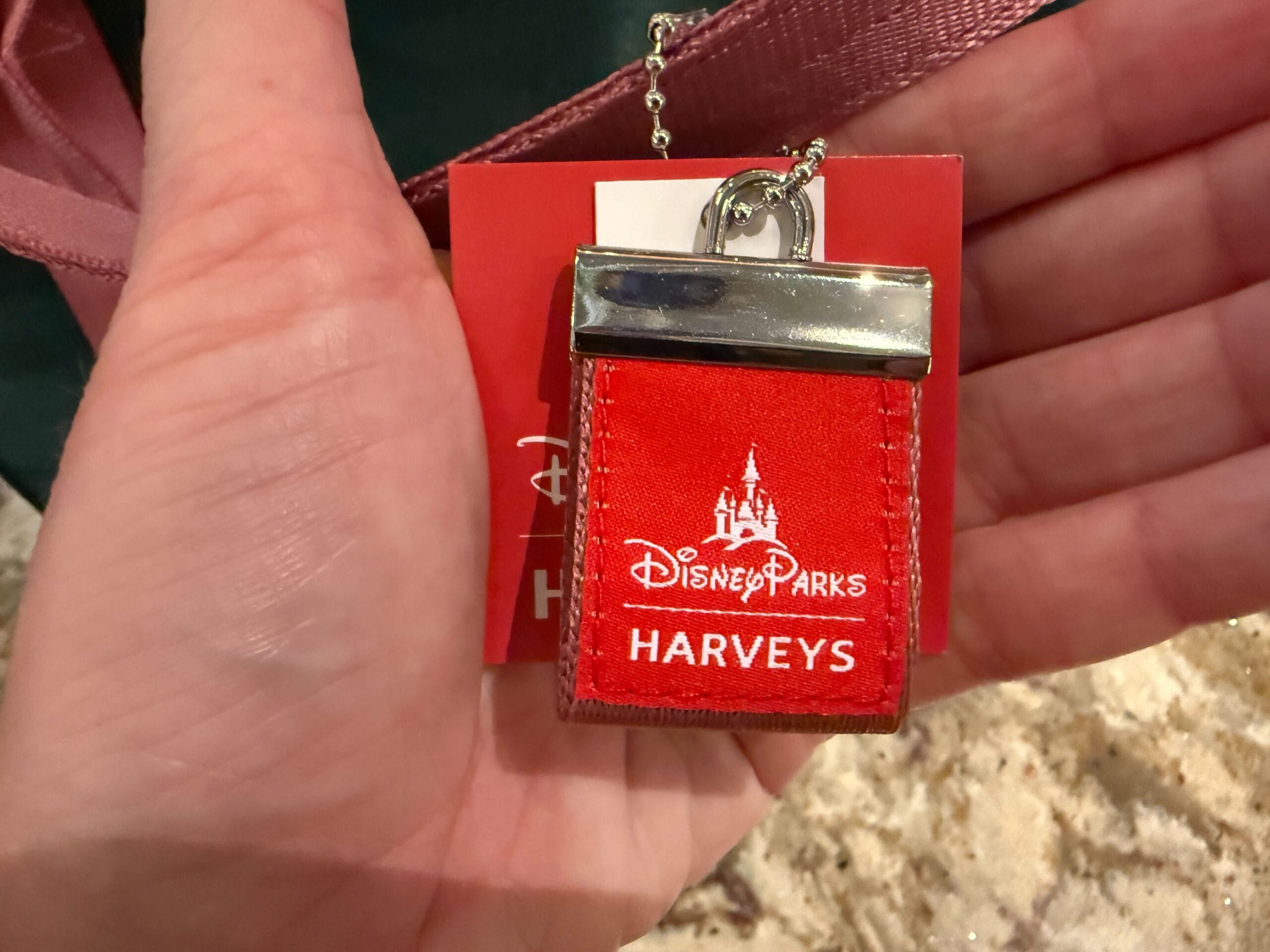 A Disney Parks Harveys red logo charm