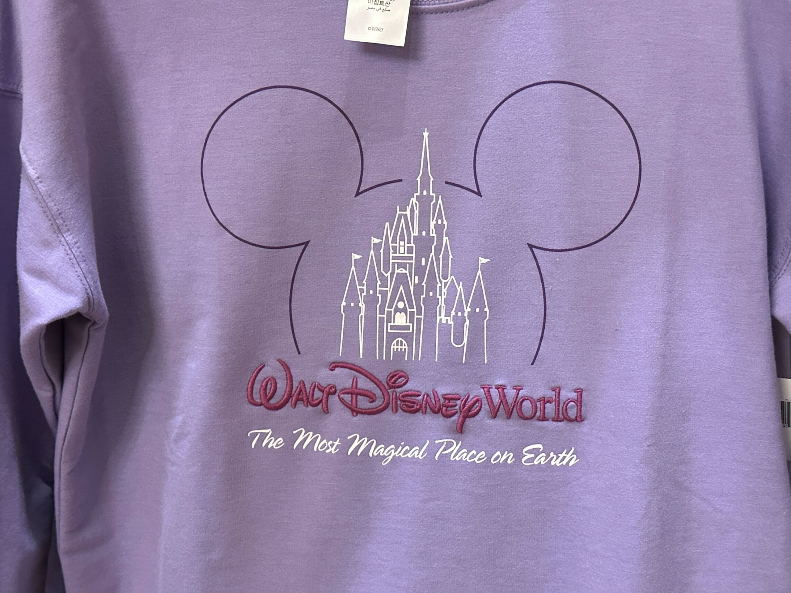 Purple sweatshirt featuring Mickey Mouse ears and Cinderella Castle outline, classic to Walt Disney World, plus park slogan text.