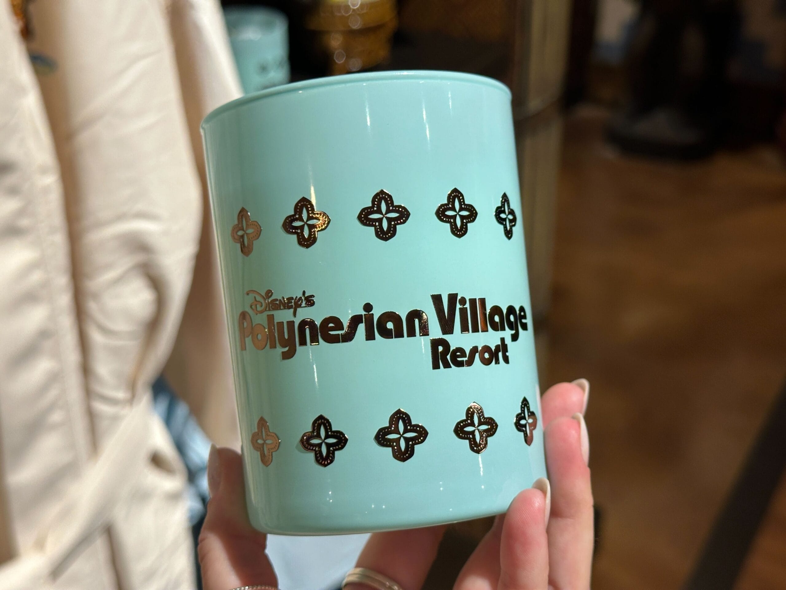 A light blue mug featuring “Disney’s Polynesian Village Resort” in gold, evoking tropical Disney park vibes