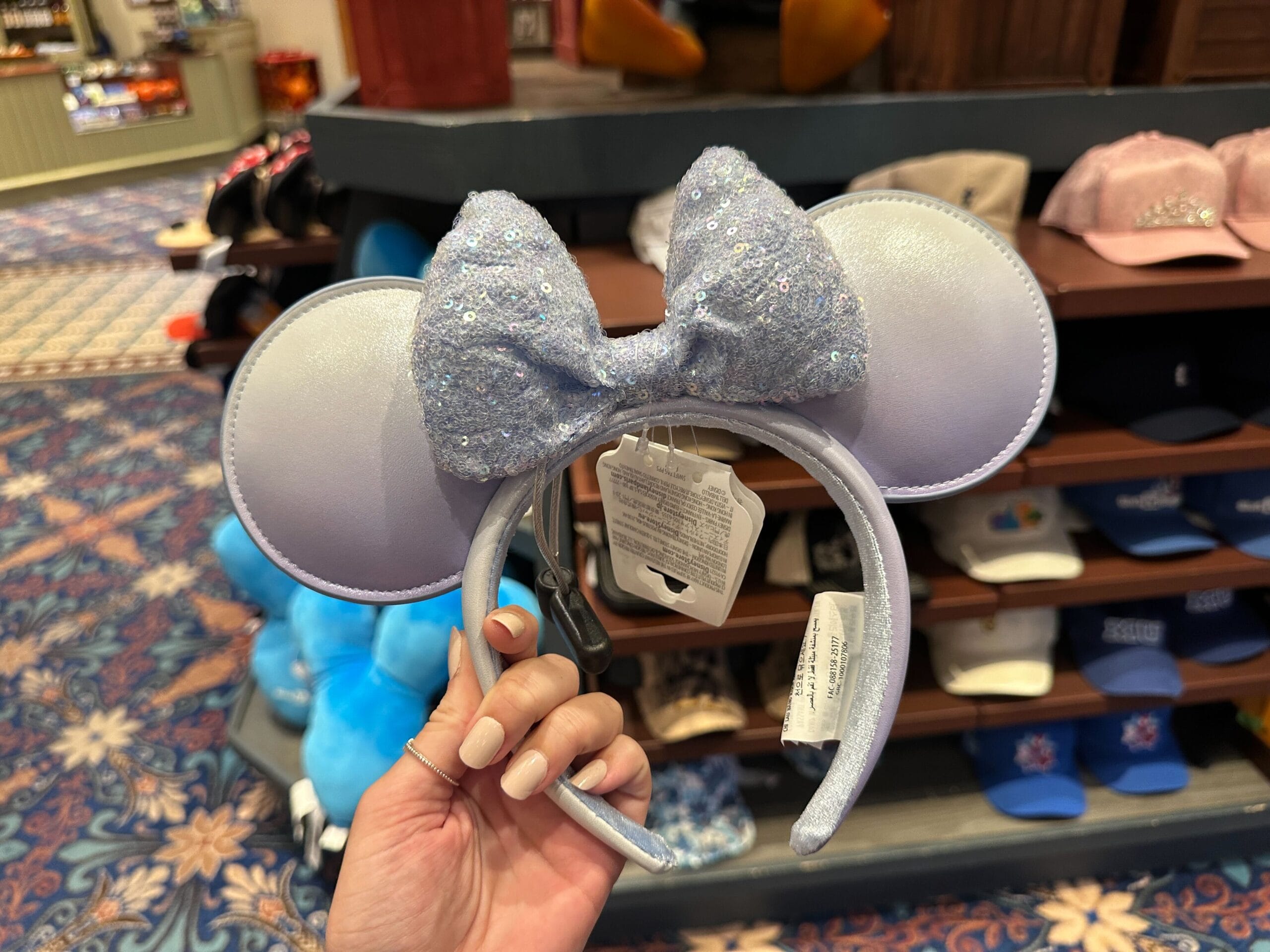 Hand holding a sparkly lavender Minnie Mouse ear headband inside Port Orleans Riverside Resort, one of Walt Disney World’s hotels.