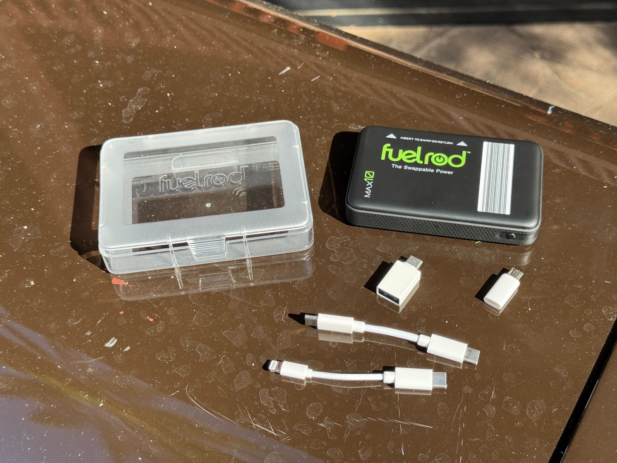A FuelRod charger kit and four adapters sit on a brown tabletop.