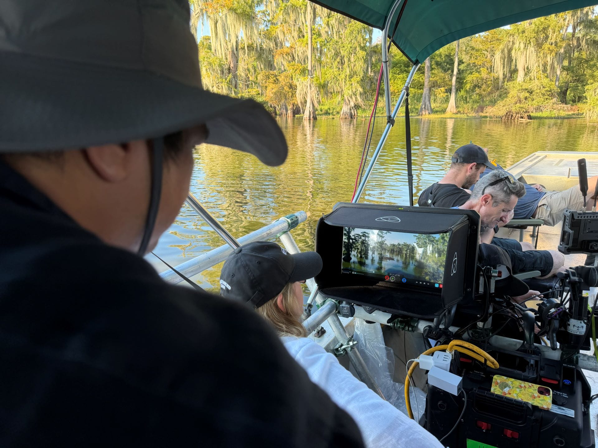 Behind the scenes crew films Soarin' Across America; monitor displays scenic water and lush trees.