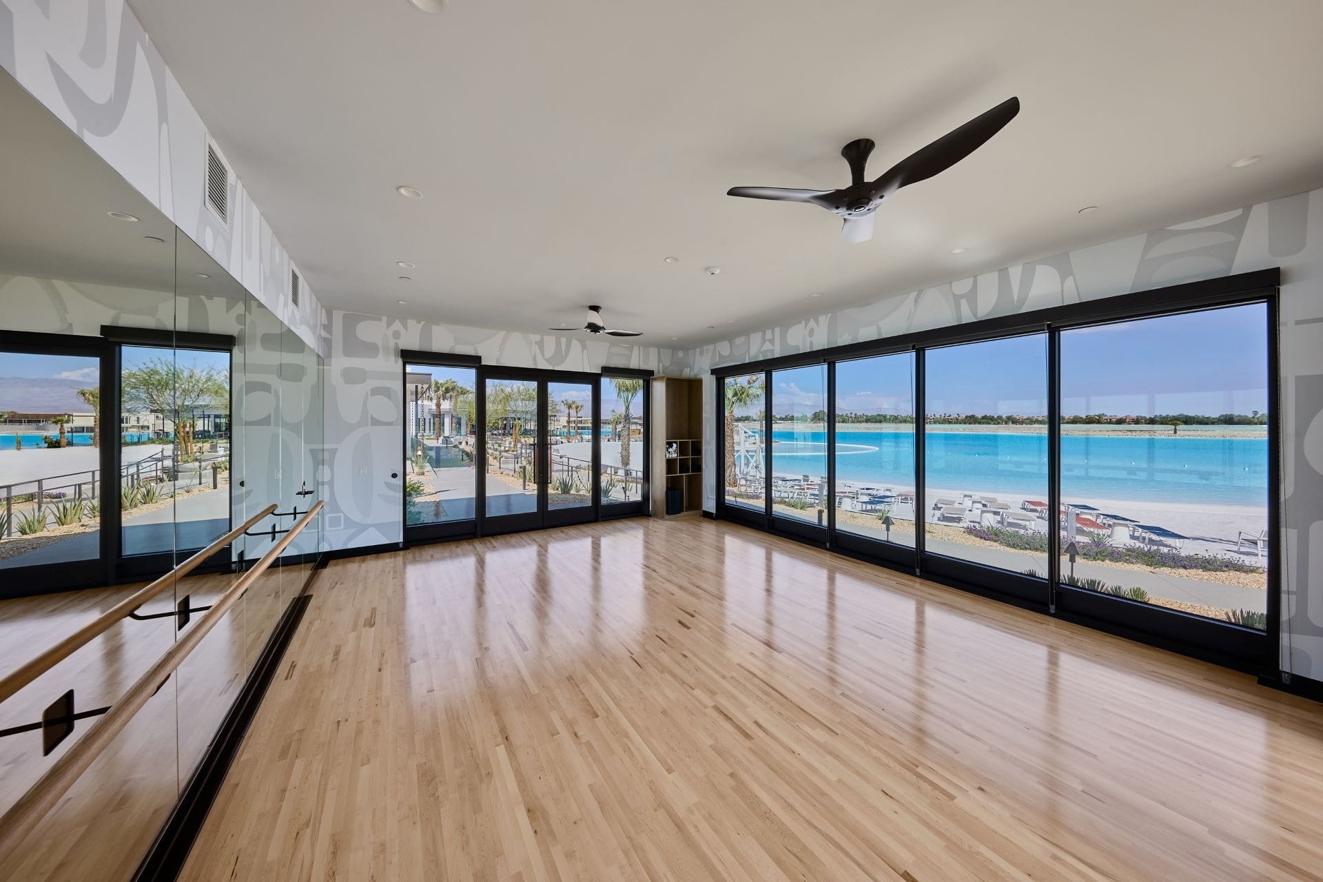 Spacious dance studio with wood floors, mirrors, and tall windows, reminiscent of Disney resort elegance, inside Cotino Community.