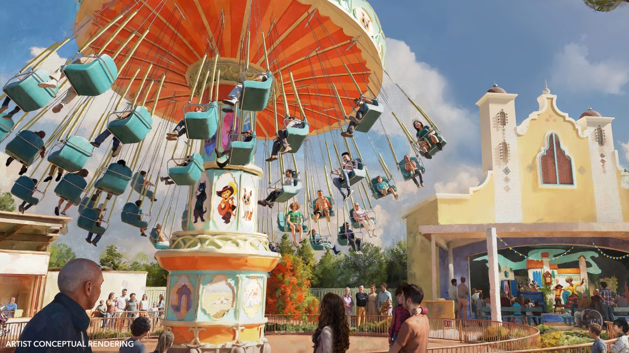 Guests soar on a vibrant swing carousel at a bustling Disney park, with a festive building—not a classic Disney castle—in the backdrop.