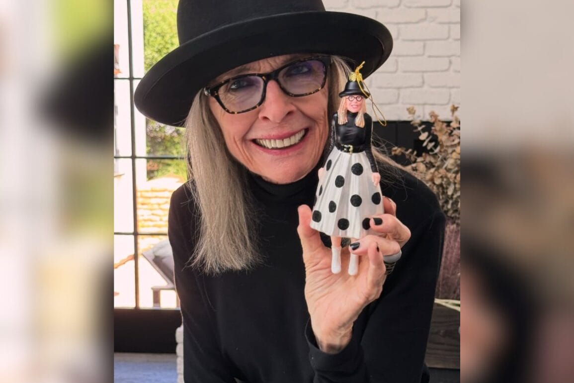 Woman in black hat and glasses at a Disney park holds a Marvel figurine also in polka dots and hat, both smiling for the photo.